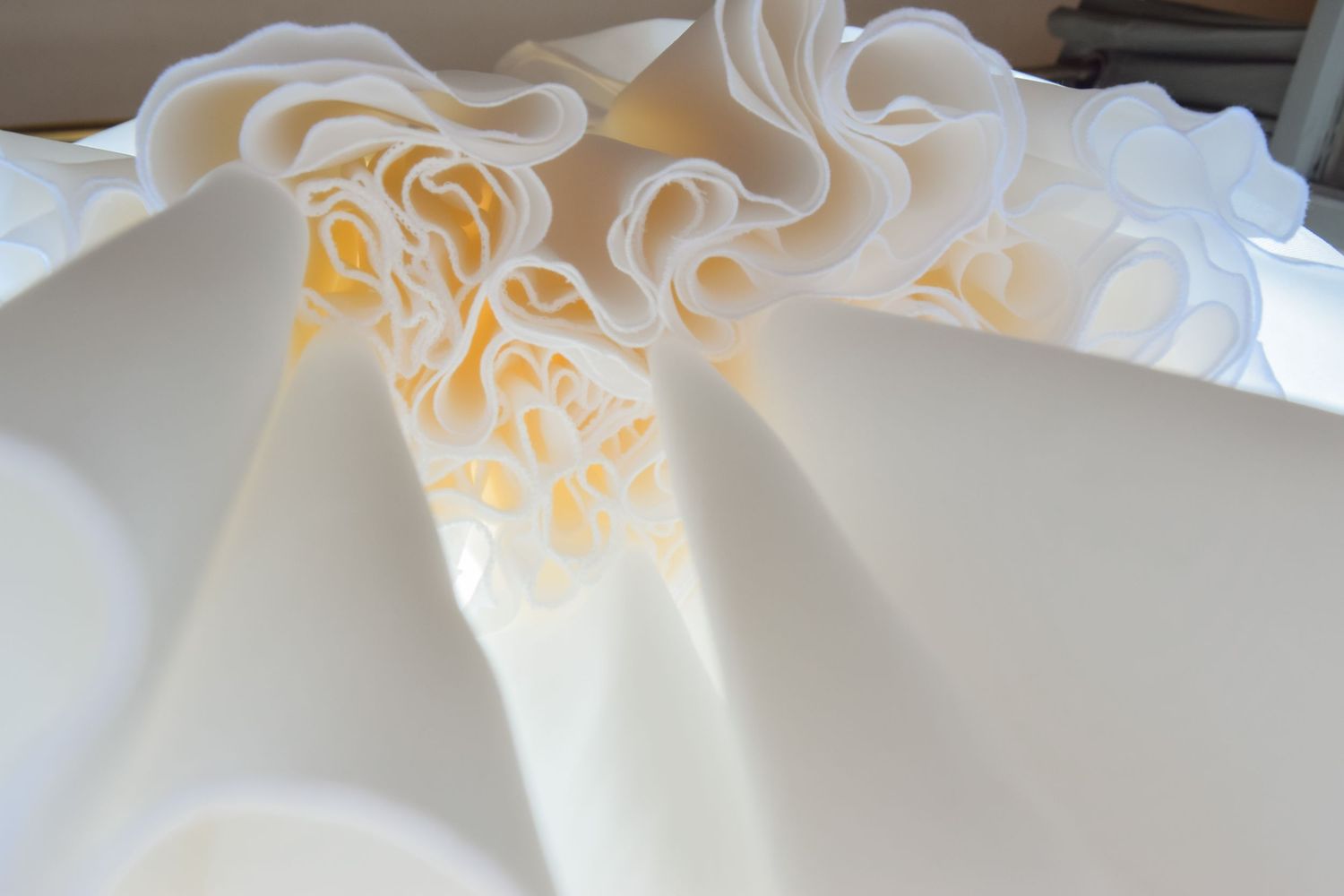 Close-up detail of intricate lace embellishments on white wedding dress fabric.