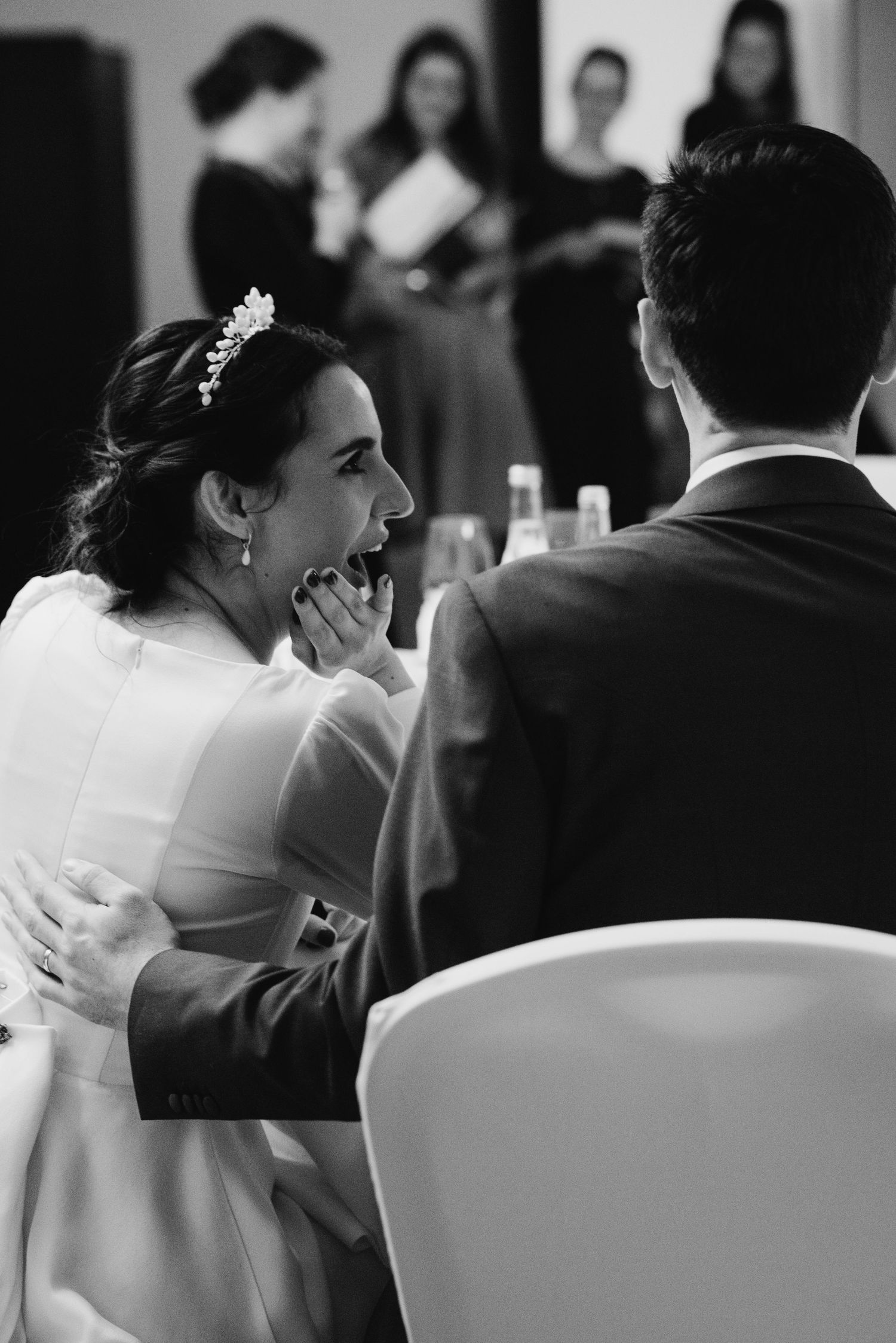 An intimate black and white wedding moment captured during a reception.