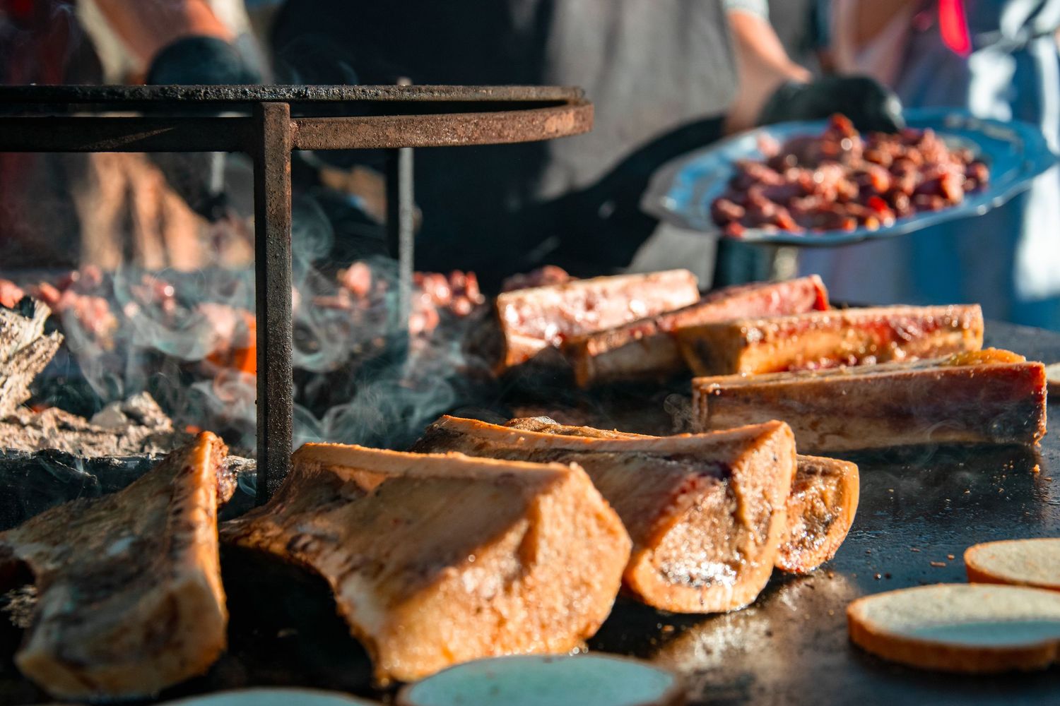 Rustic bread slices toasting on a grill with smoke rising.