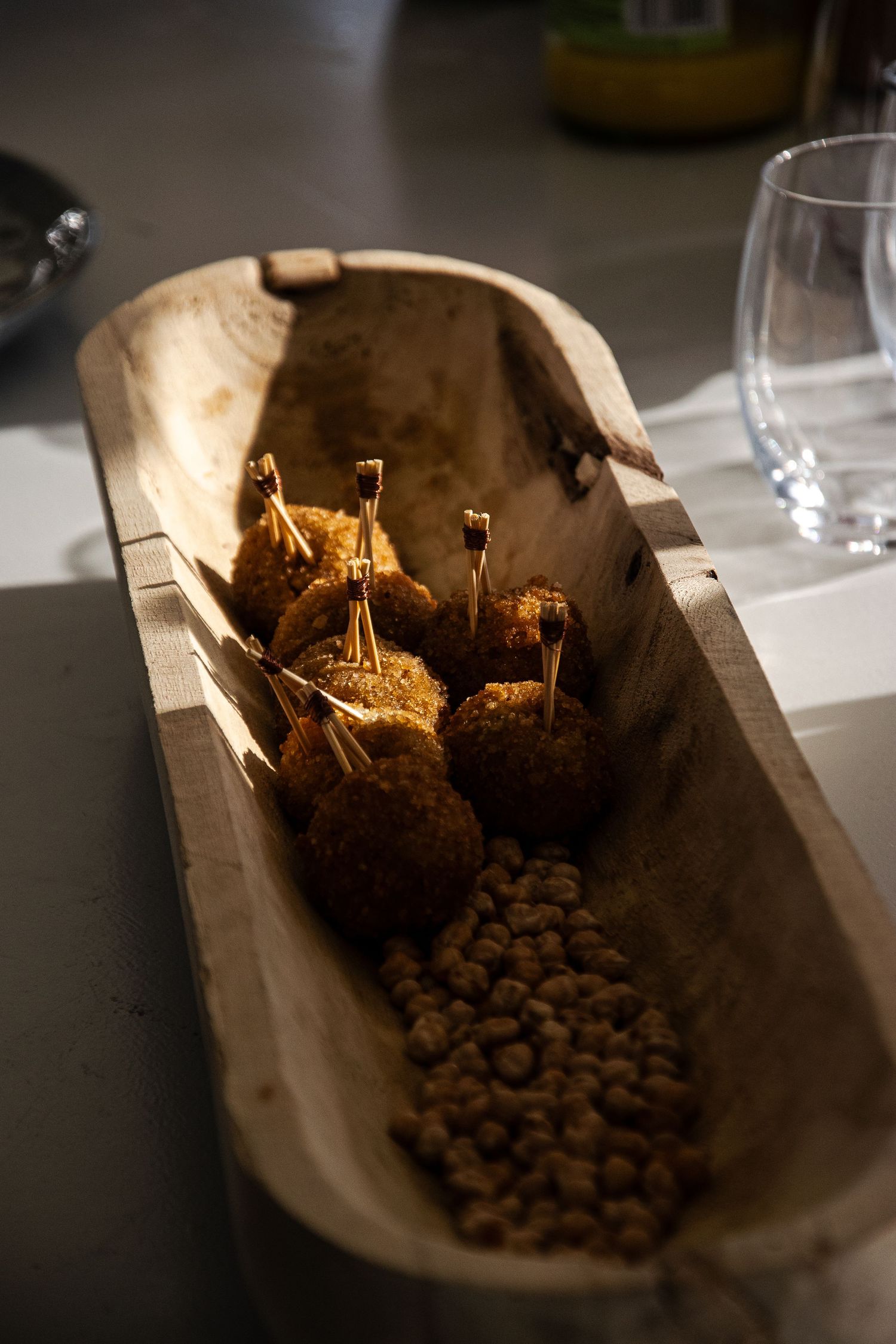 Dark roasted coffee beans spilling out of a brown paper bag onto a white surface in sequence of eight frames.