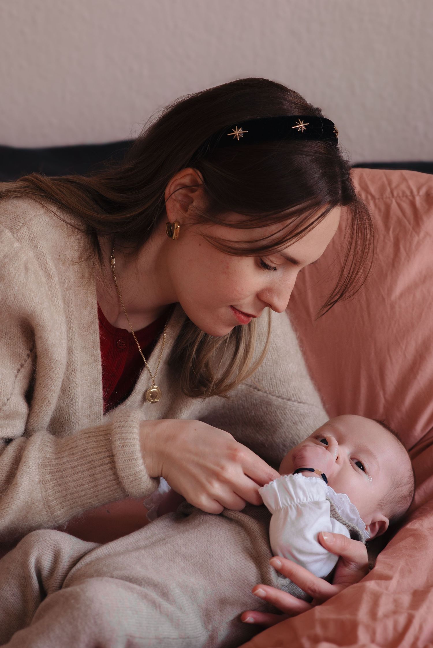 Tender moment between caregiver and baby in cozy indoor setting.