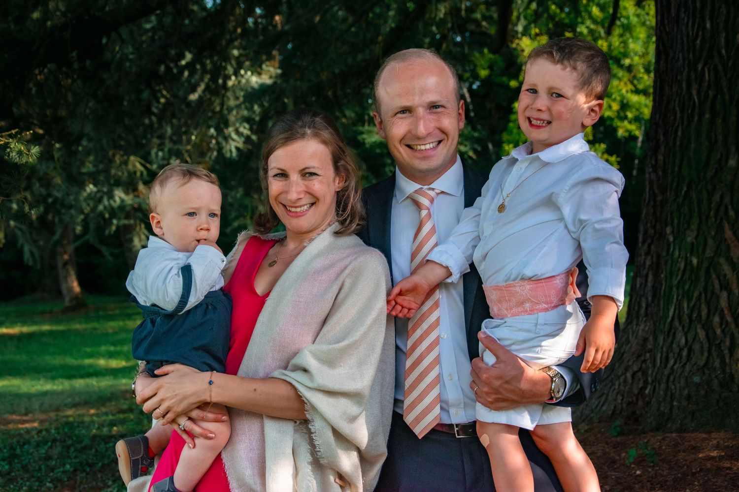 A family portrait taken outdoors with children dressed in formal attire.