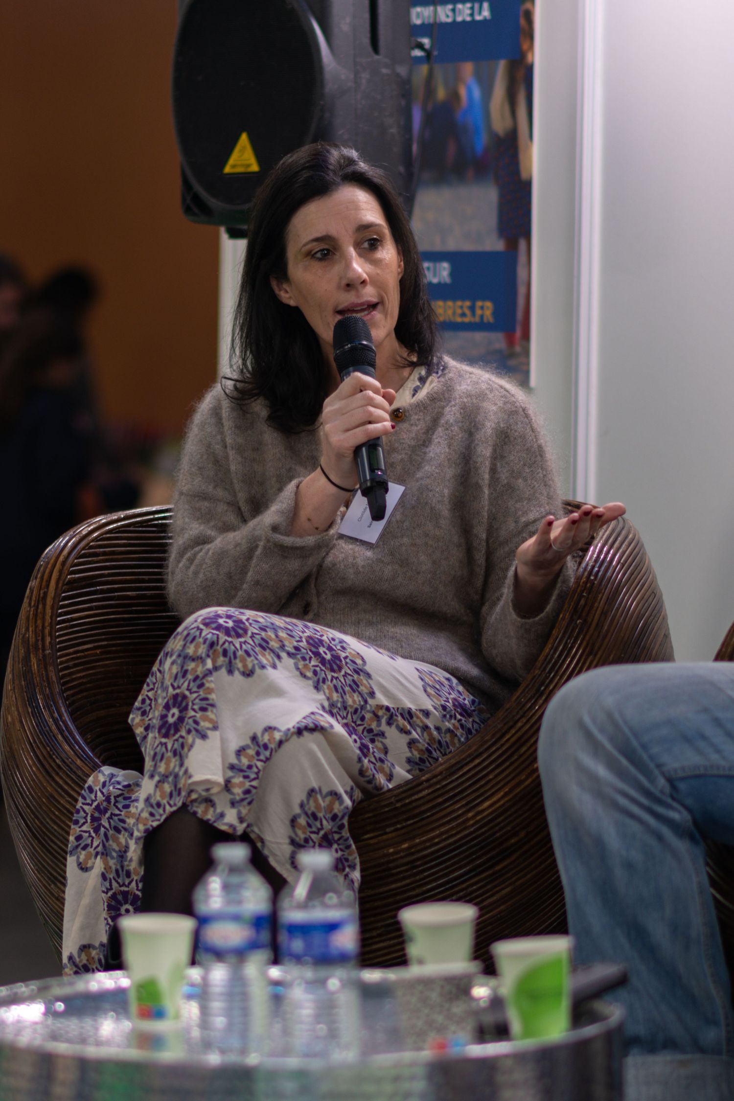 Four sequential photos show someone in a gray sweater sitting on a wicker chair while drinking water.