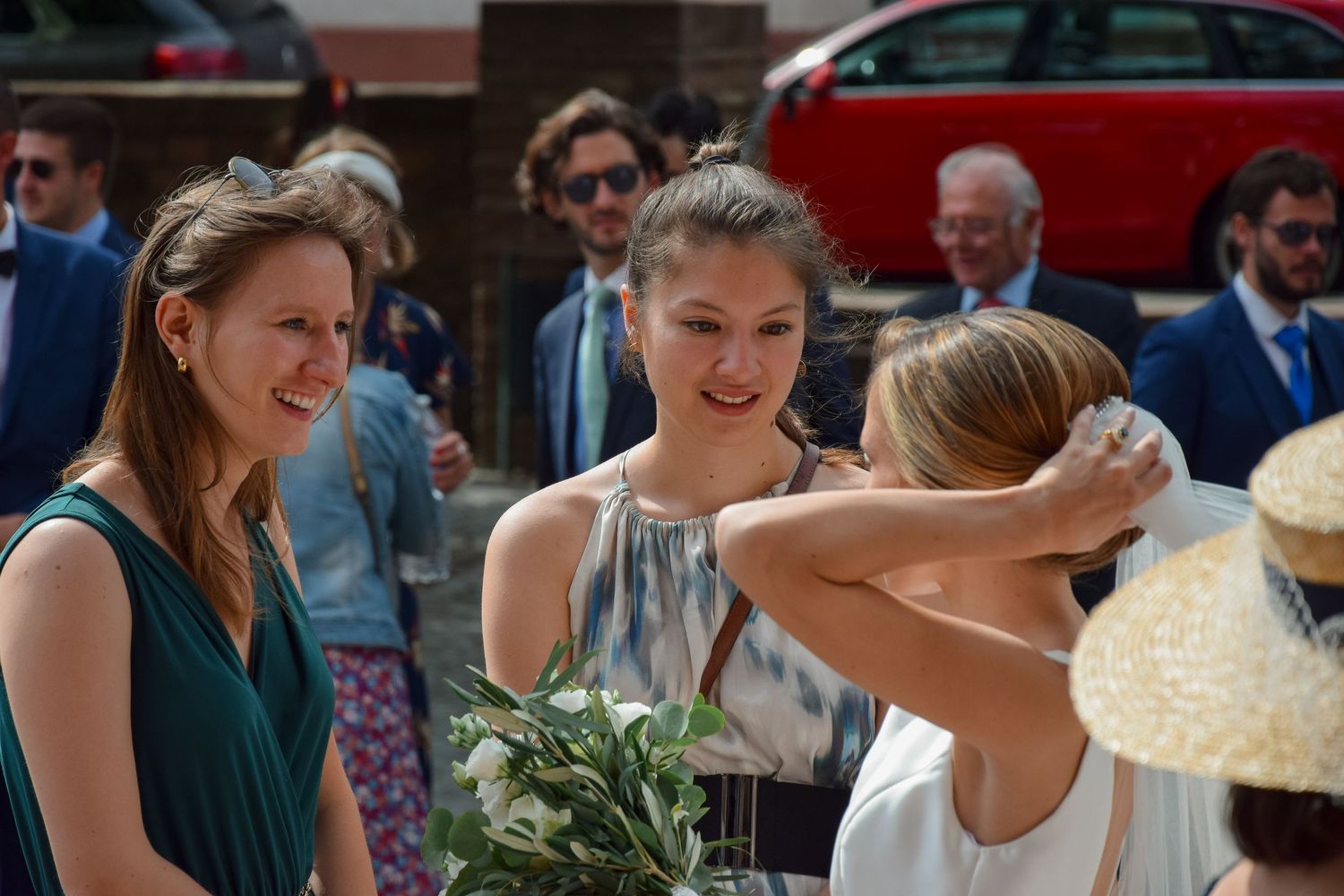 Wedding guests enjoy a candid outdoor moment with flowers and laughter at a celebratory gathering.