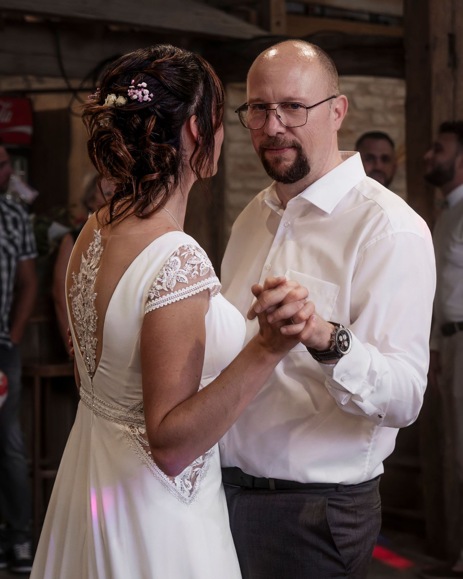 A couple shares an intimate dance together at their wedding reception in a rustic indoor venue.
