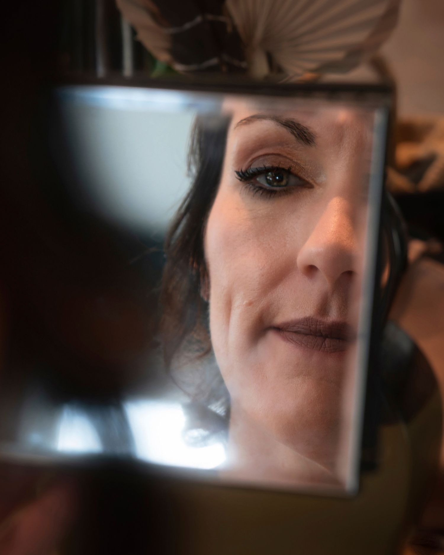 A series of close-up selfie photos showing partial views of a face in dramatic lighting and reflective surfaces.