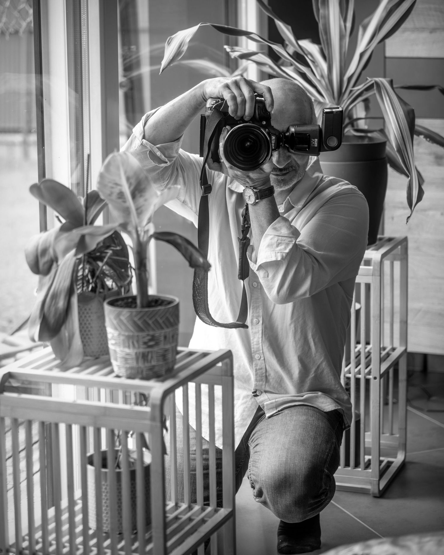 A montage of hands watering plants on a porch shown from different angles in moody black and white photography.