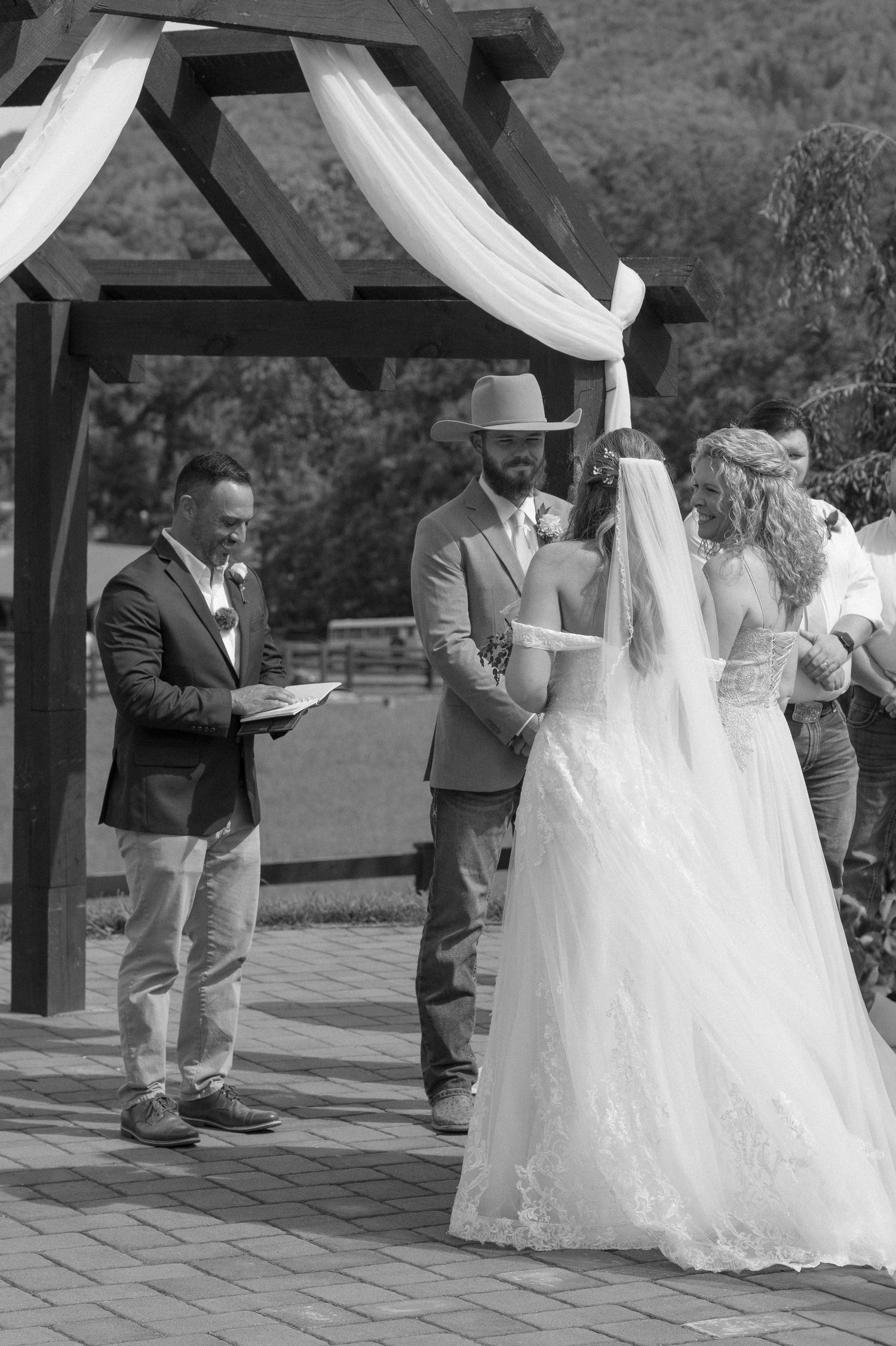 A wedding couple shares their first dance together on an outdoor patio decorated with white draping.