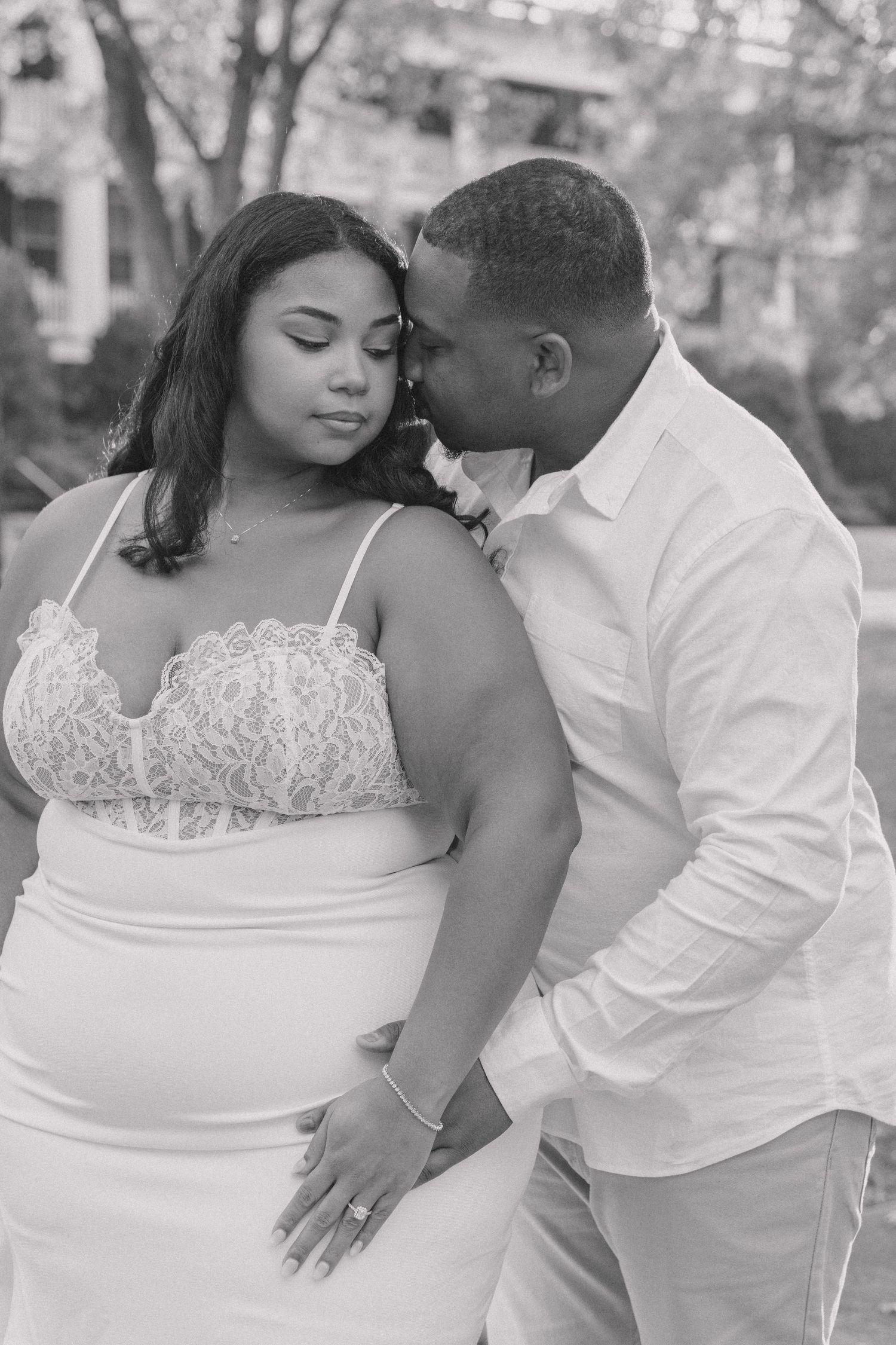 A romantic black and white photo series showing tender moments between a couple in white attire outdoors.
