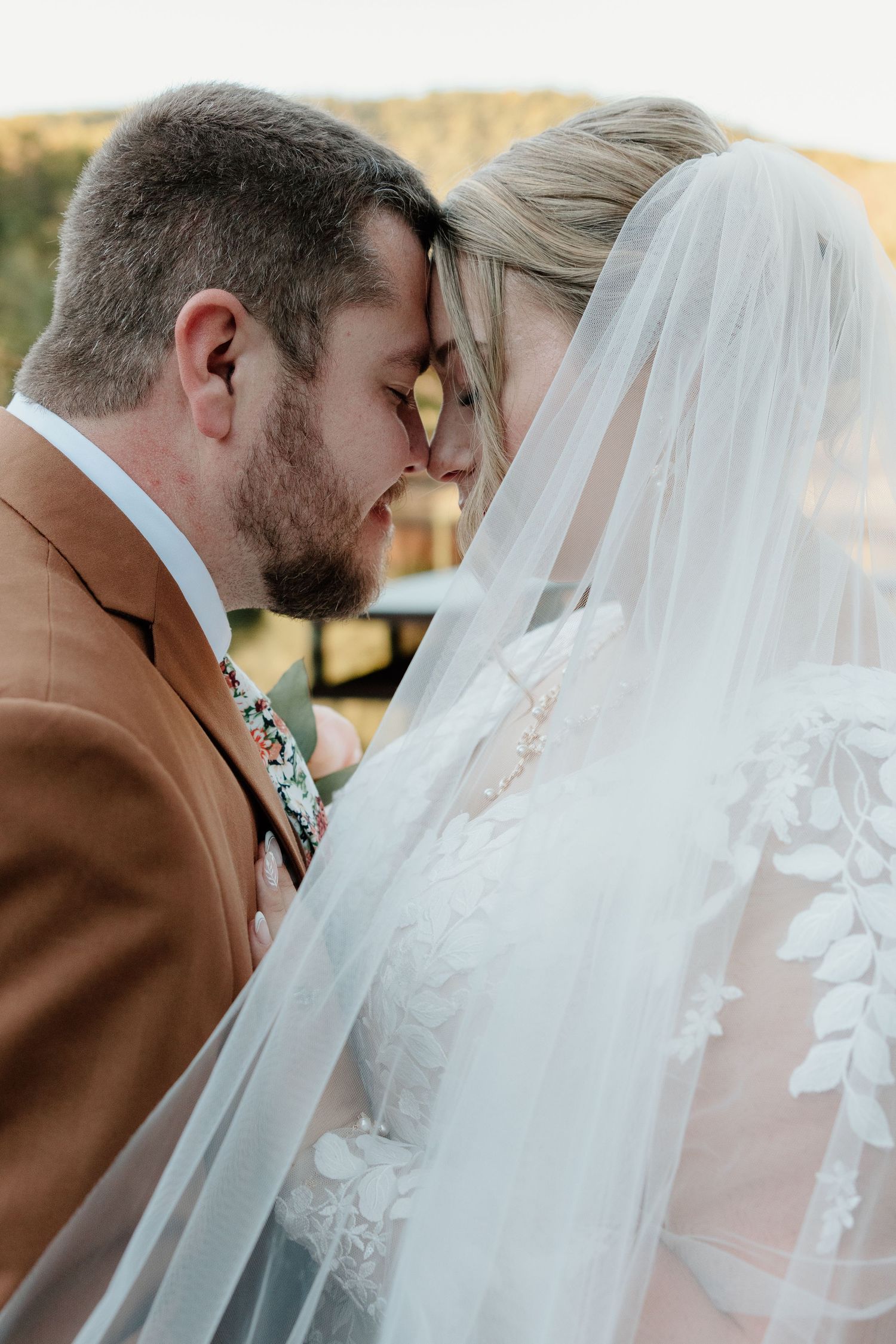 A romantic wedding couple shares five tender kisses in a sequence of intimate veil-draped moments.