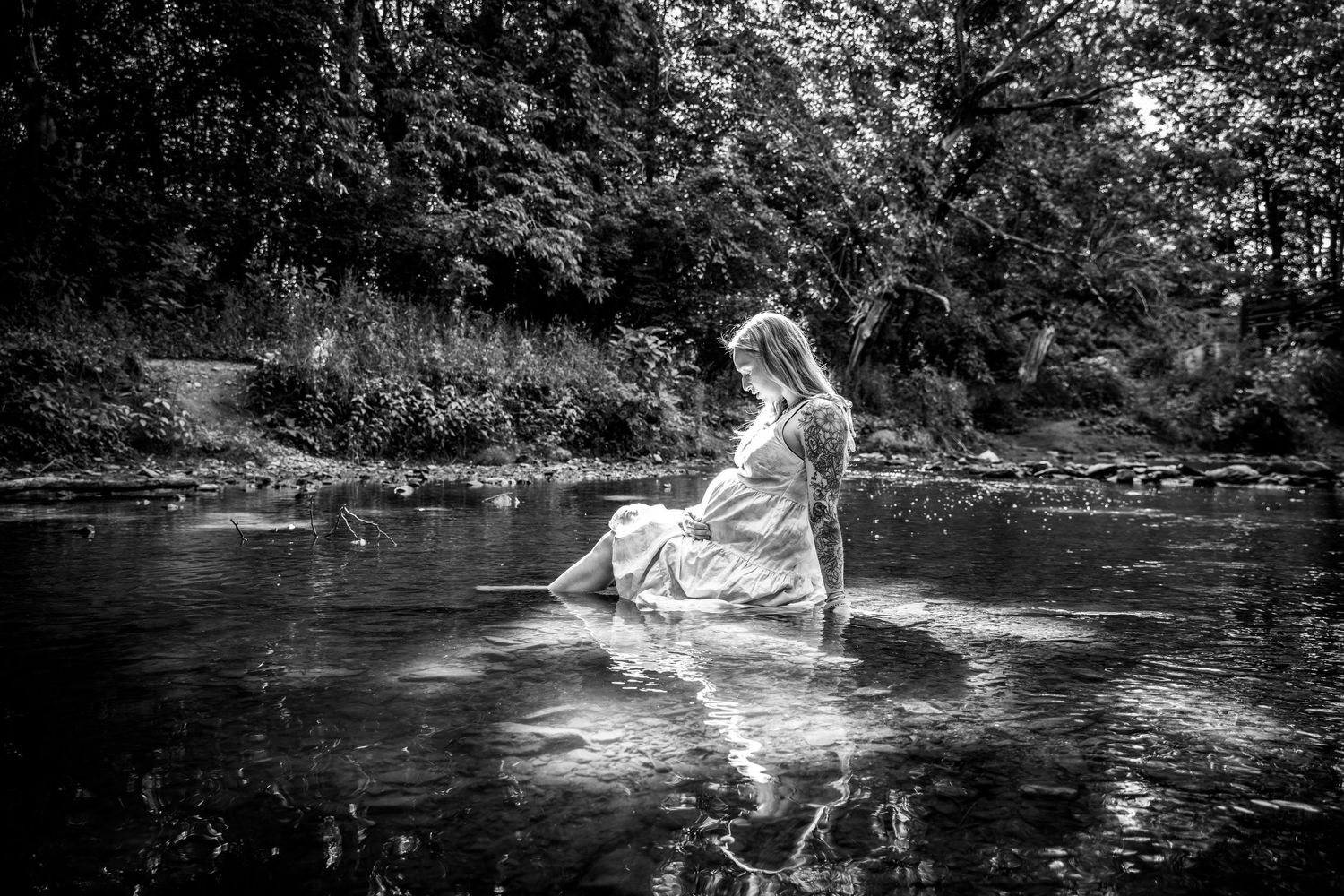 Artistic black and white photograph capturing movement in water with flowing white fabric.