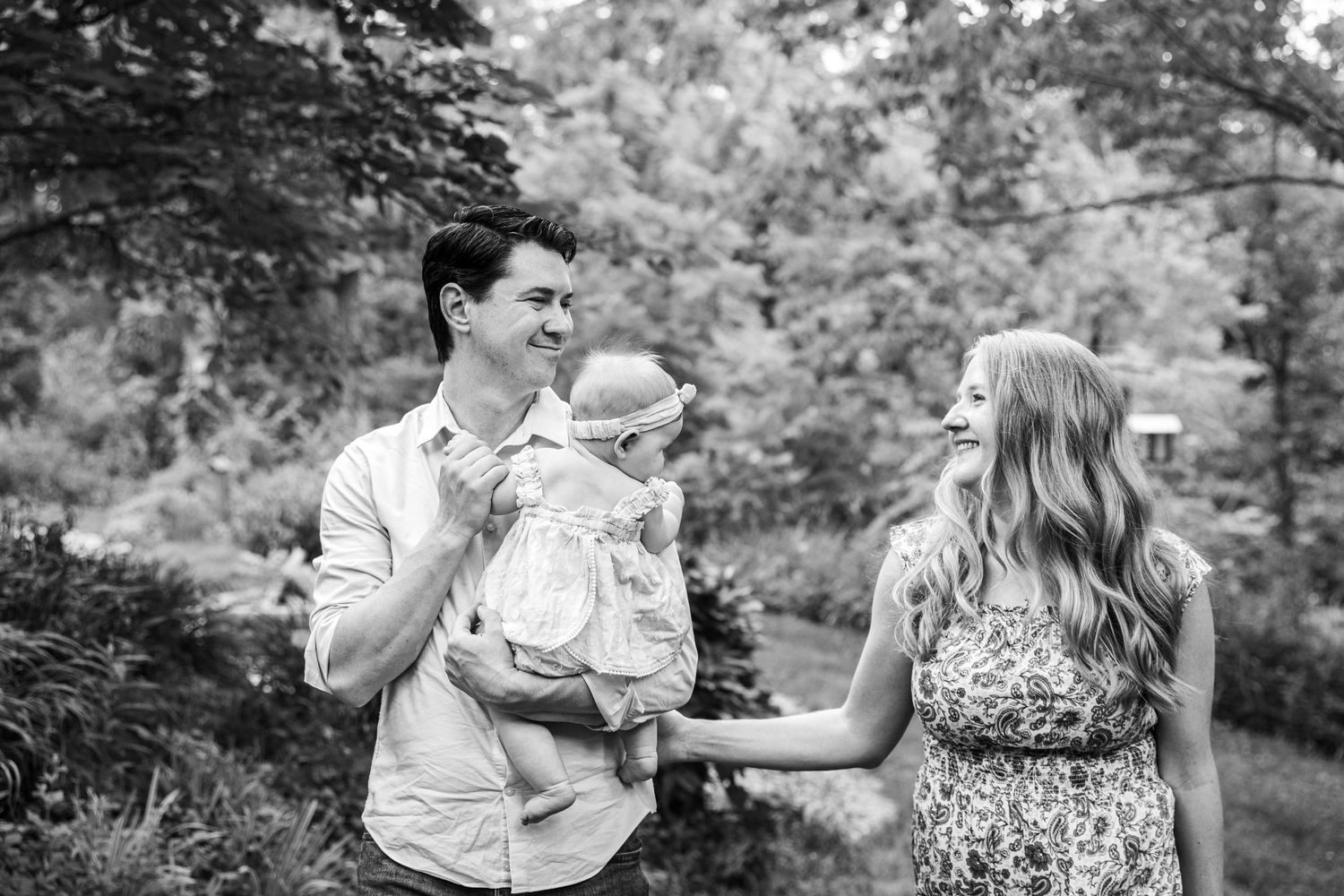 Family enjoying a joyful moment together outdoors in a black and white photo.