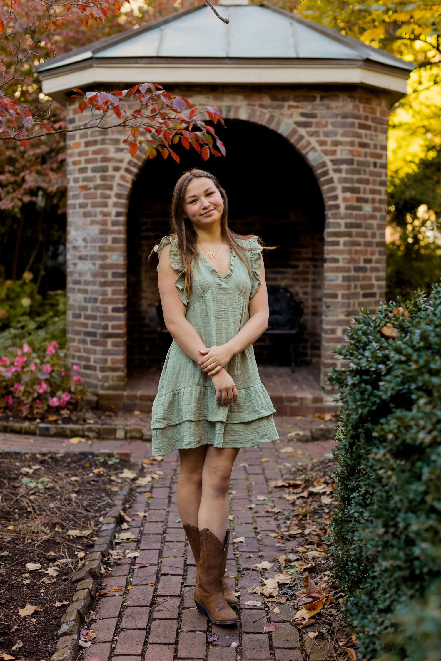 A series of outdoor autumn portraits taken in front of a brick structure surrounded by colorful fall foliage.