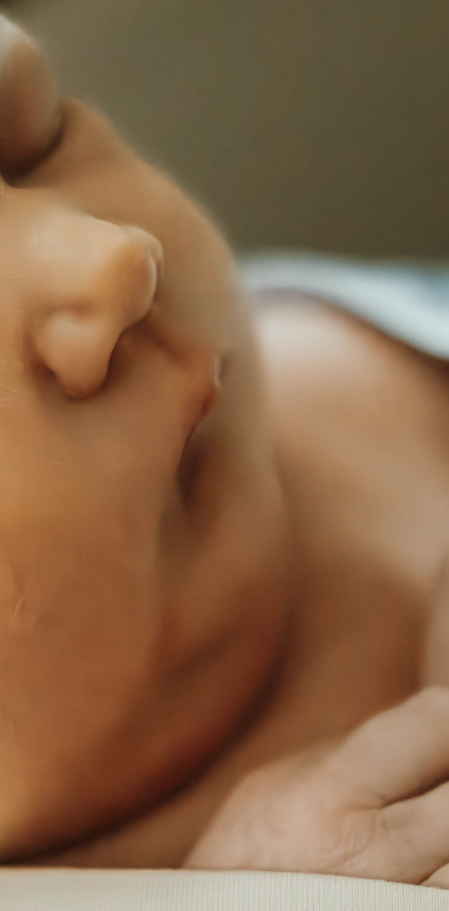 A close-up macro photograph of a sleeping baby's nose and mouth showing peaceful, gentle breathing.