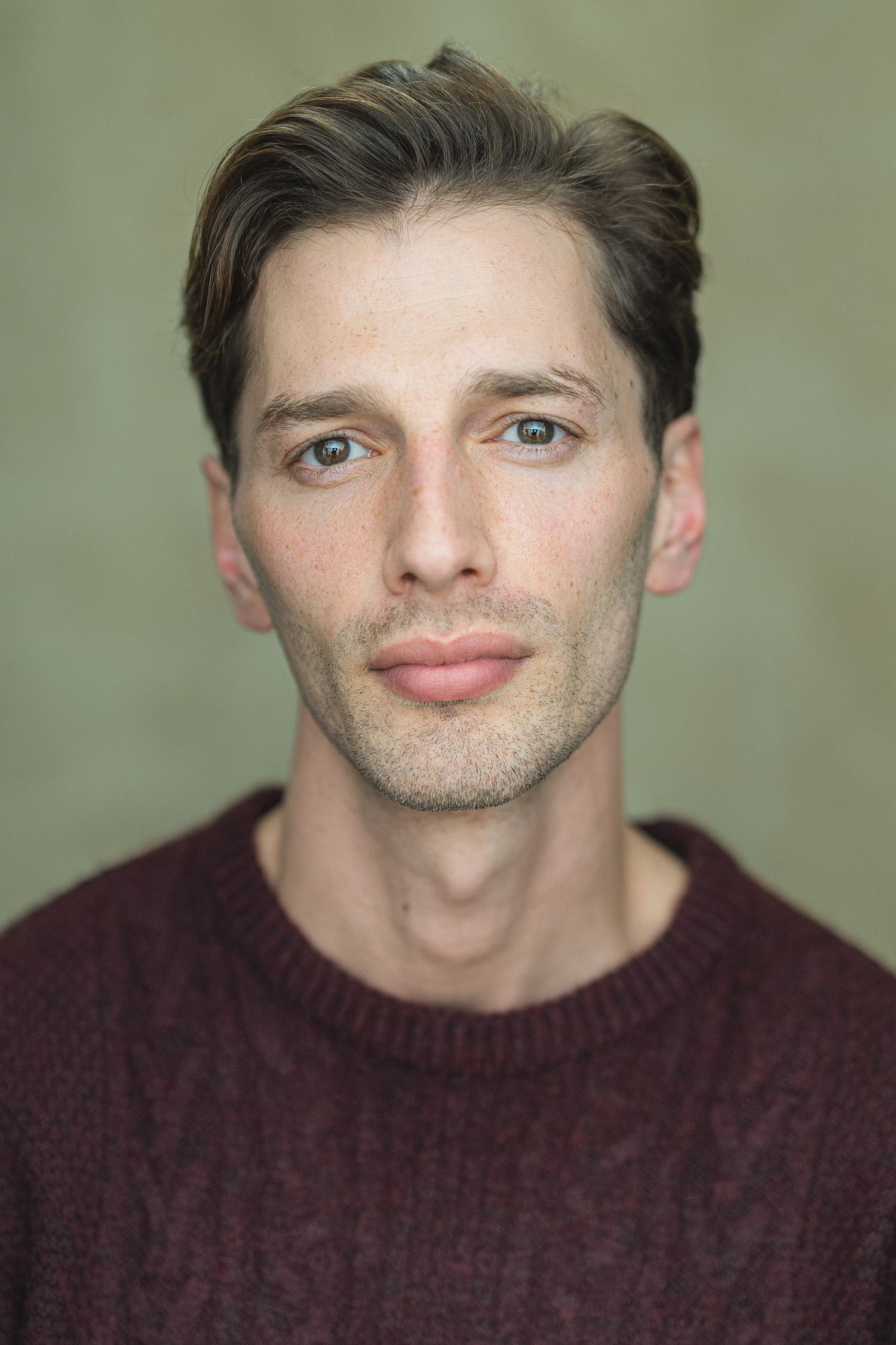 A series of five portrait photos showing someone in a burgundy sweater making playful facial expressions.