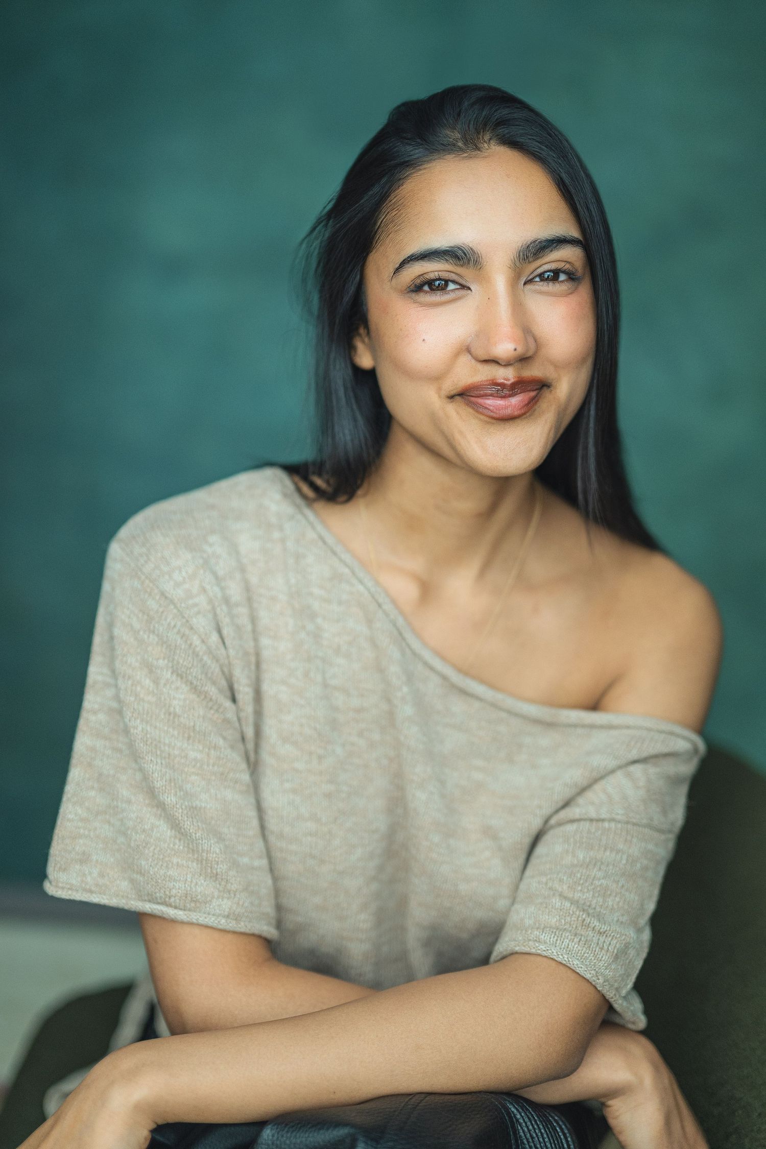A series of four casual portrait photos showing someone in a gray top against a teal background, smiling warmly.