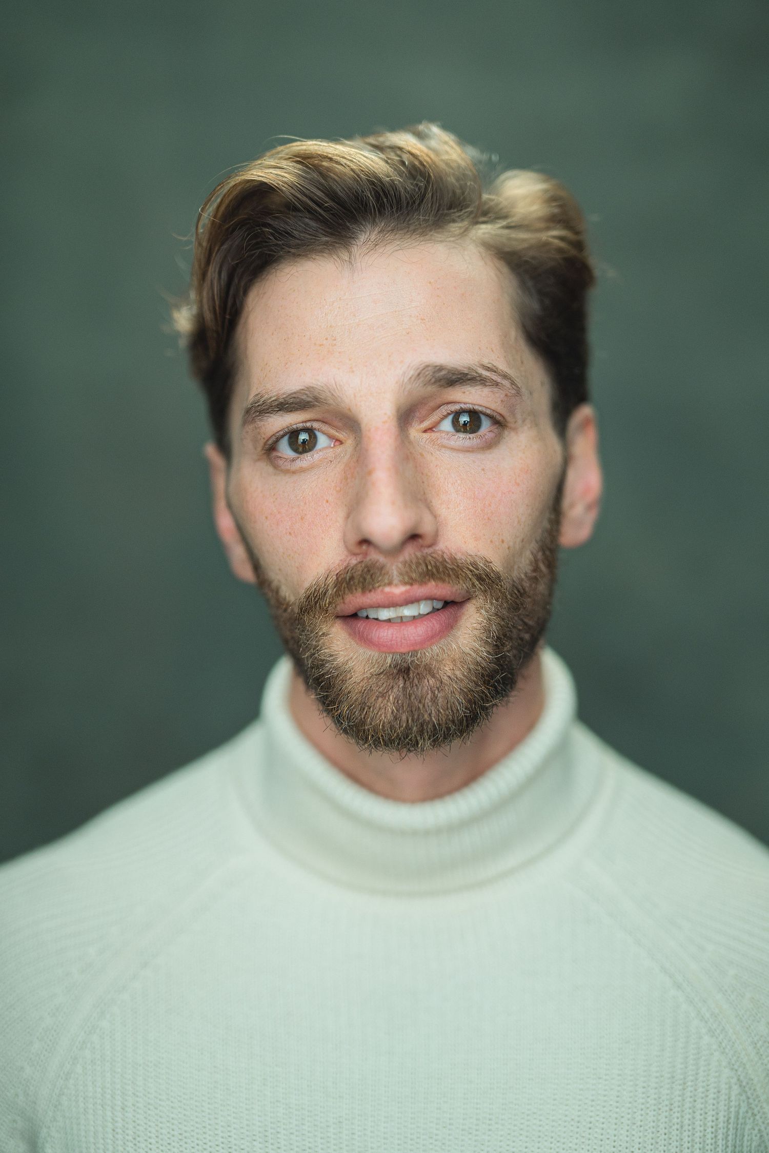 Portrait series of someone wearing a white turtleneck sweater against a green background.