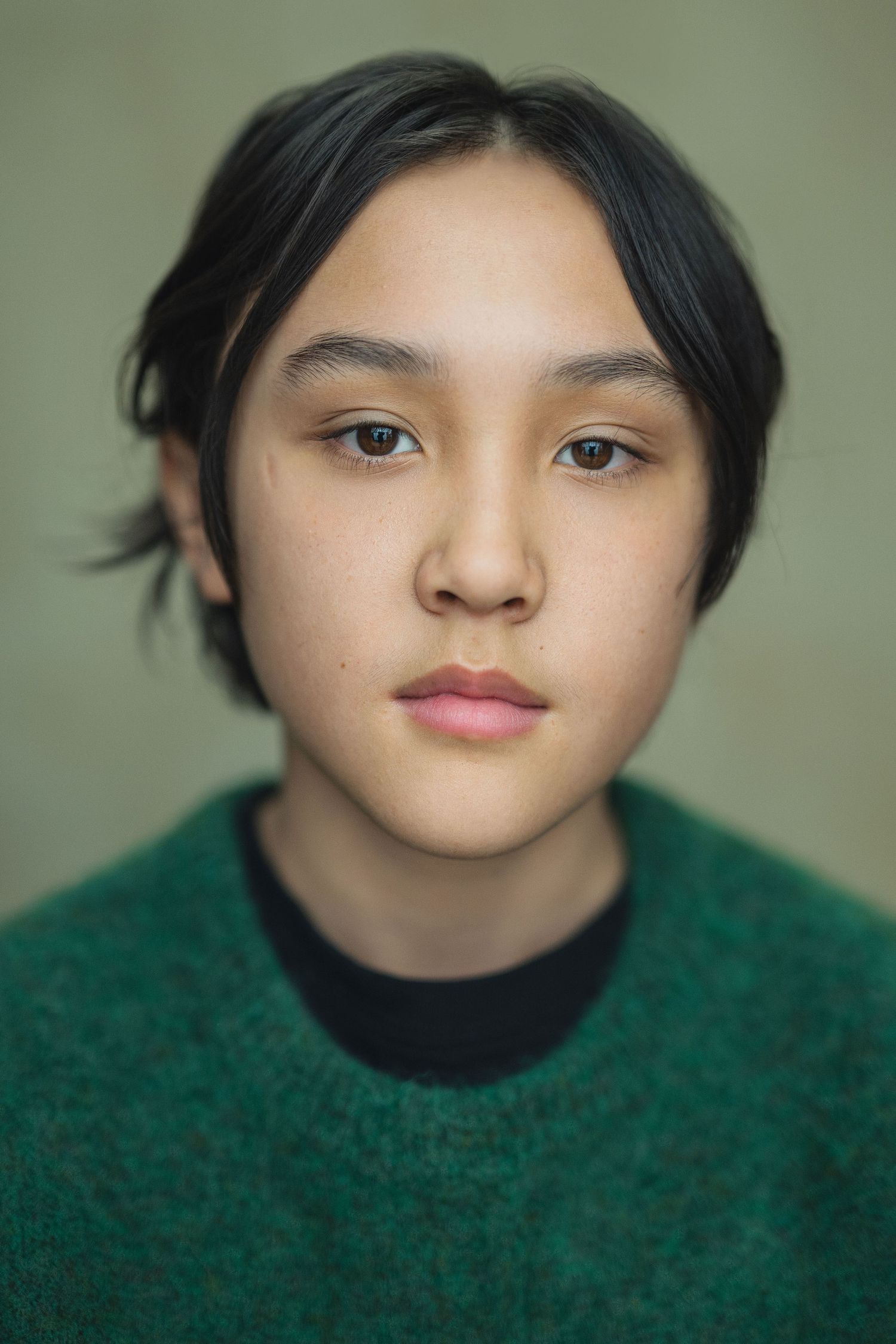 Close-up portrait series showing different angles of a person wearing a green turtleneck sweater against a neutral background.