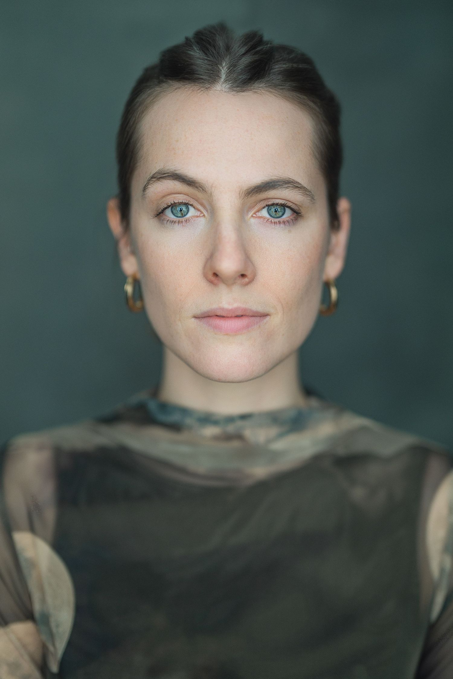 Portrait series showing a face emerging from shadows against a dark teal background in four progressive stages.