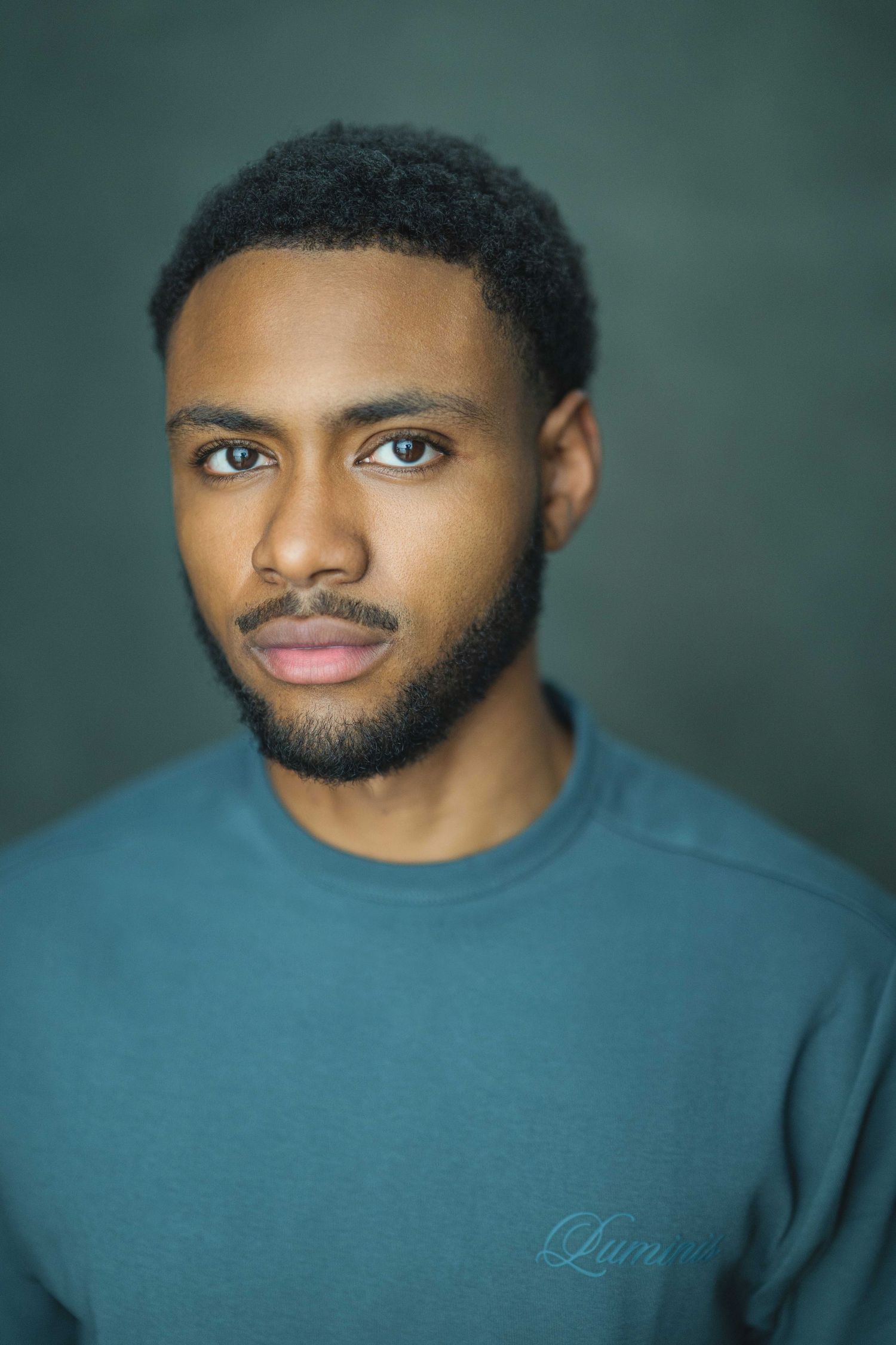 A series of professional headshots showing different angles of someone wearing a blue sweater against a dark background.