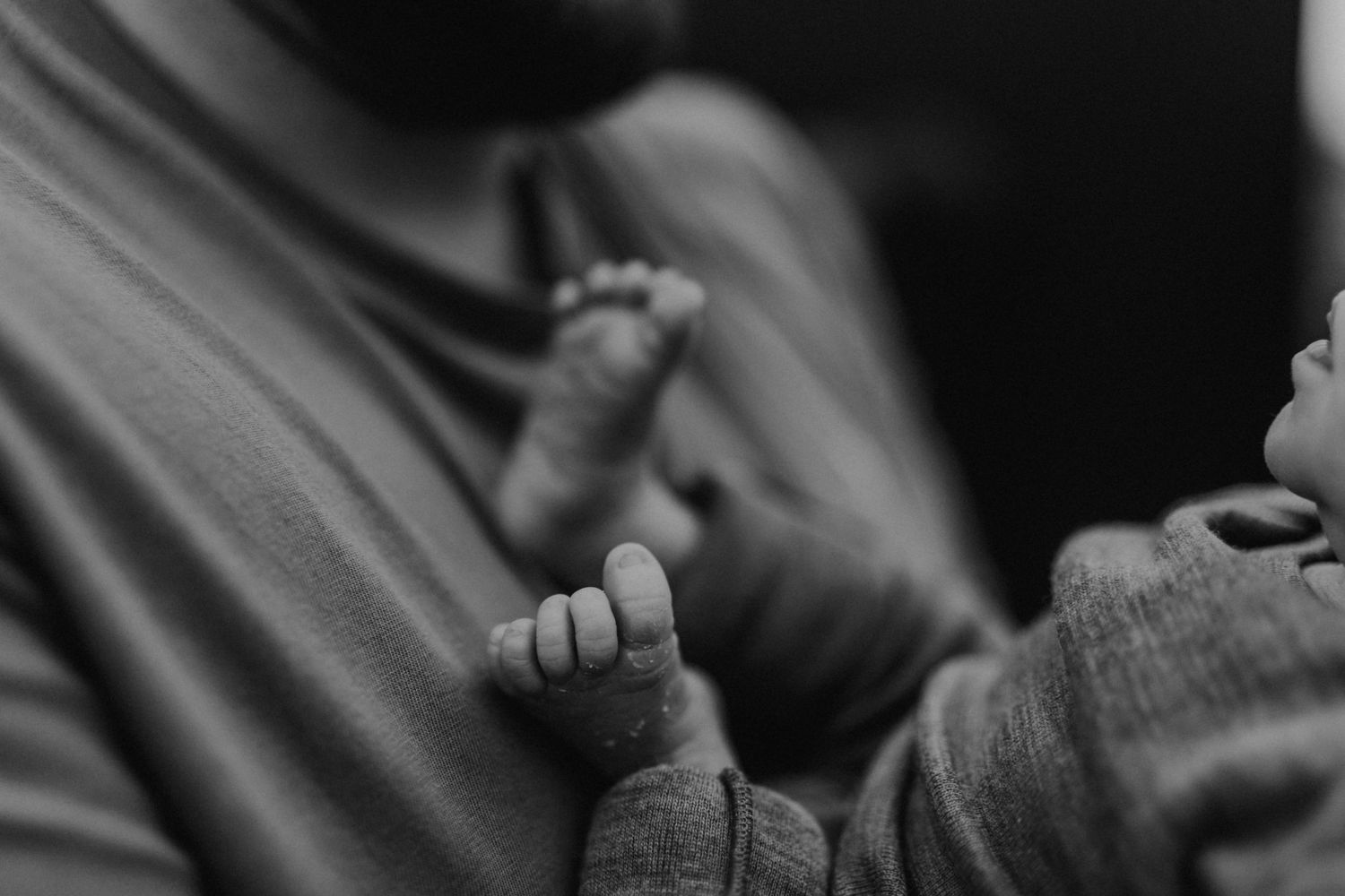 Black and white close-up of tiny infant feet.