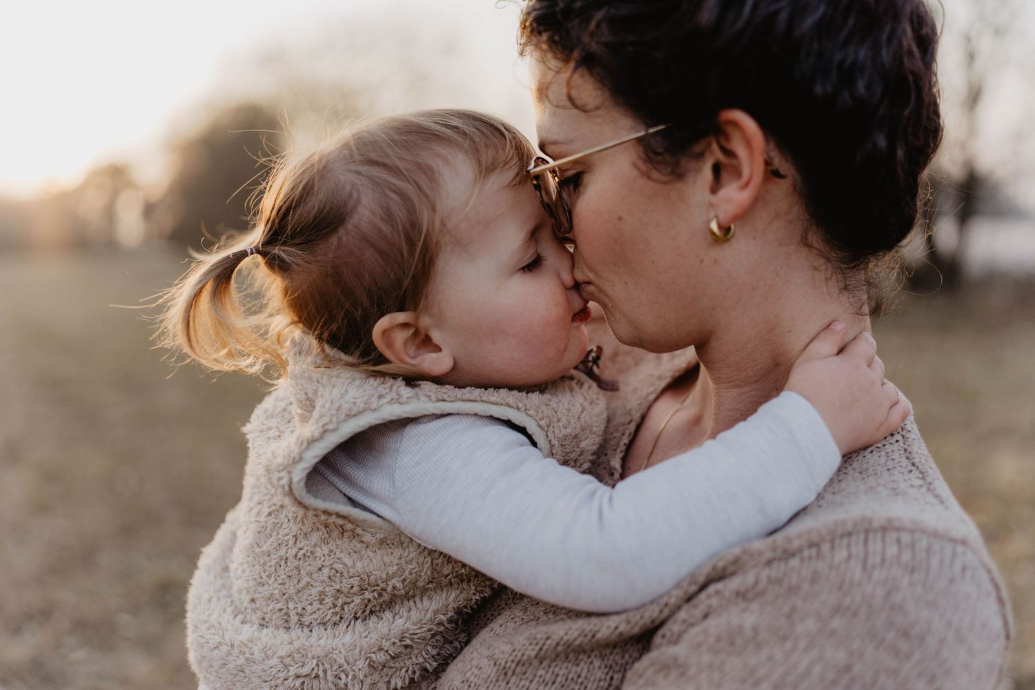 A warm embrace between parent and child during an outdoor photo session.