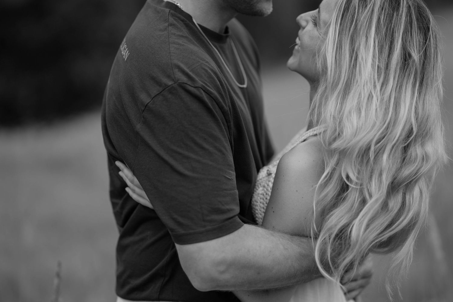 Romantic couple embracing in black and white portrait with soft focus and intimate connection.
