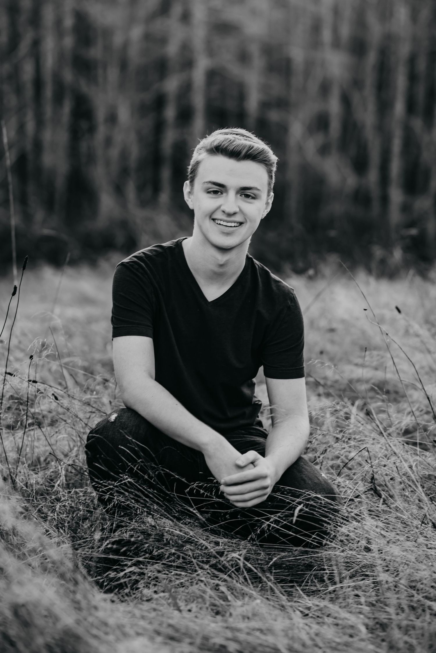 Senior boy crouched in a field