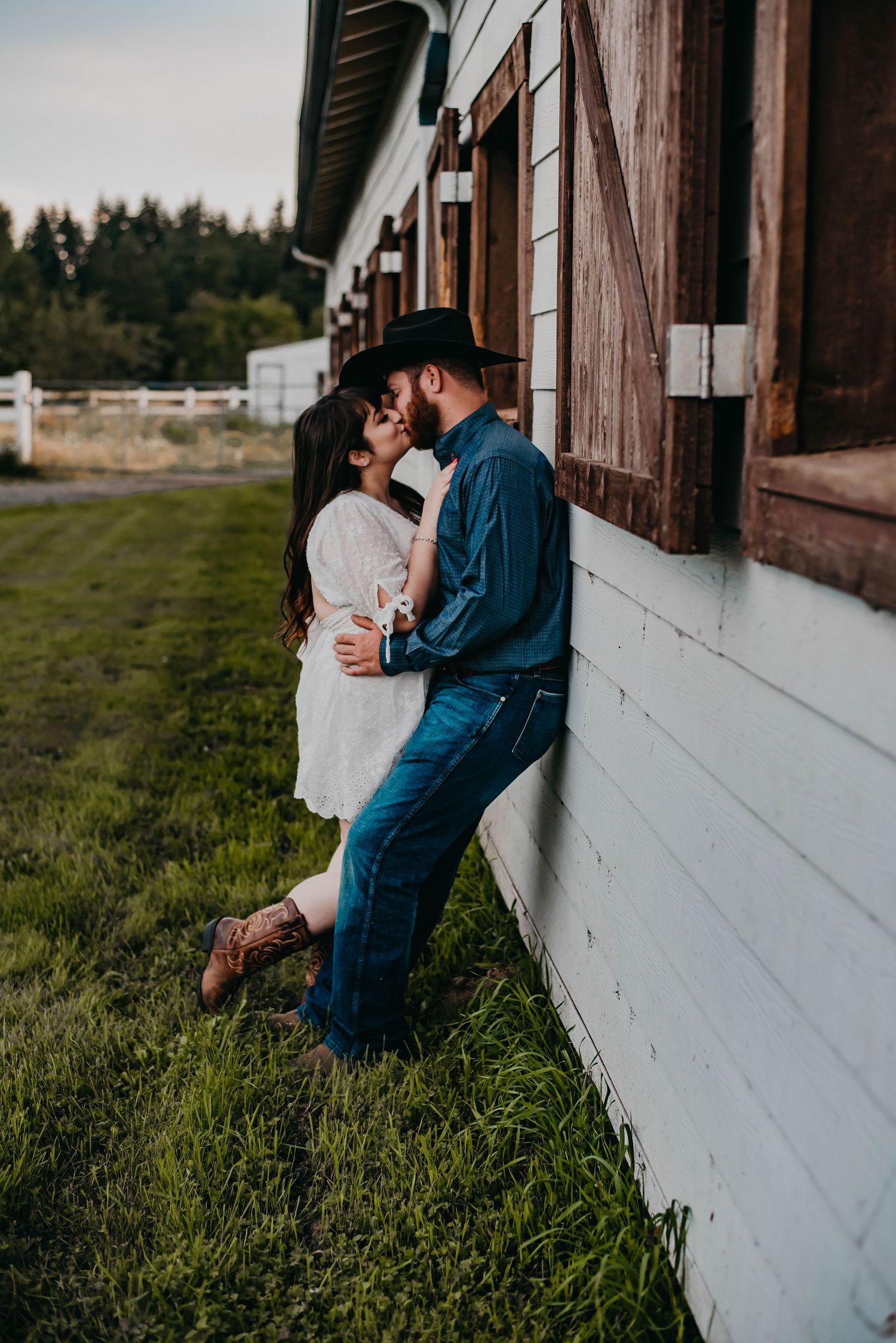 Couple leaning against a barn