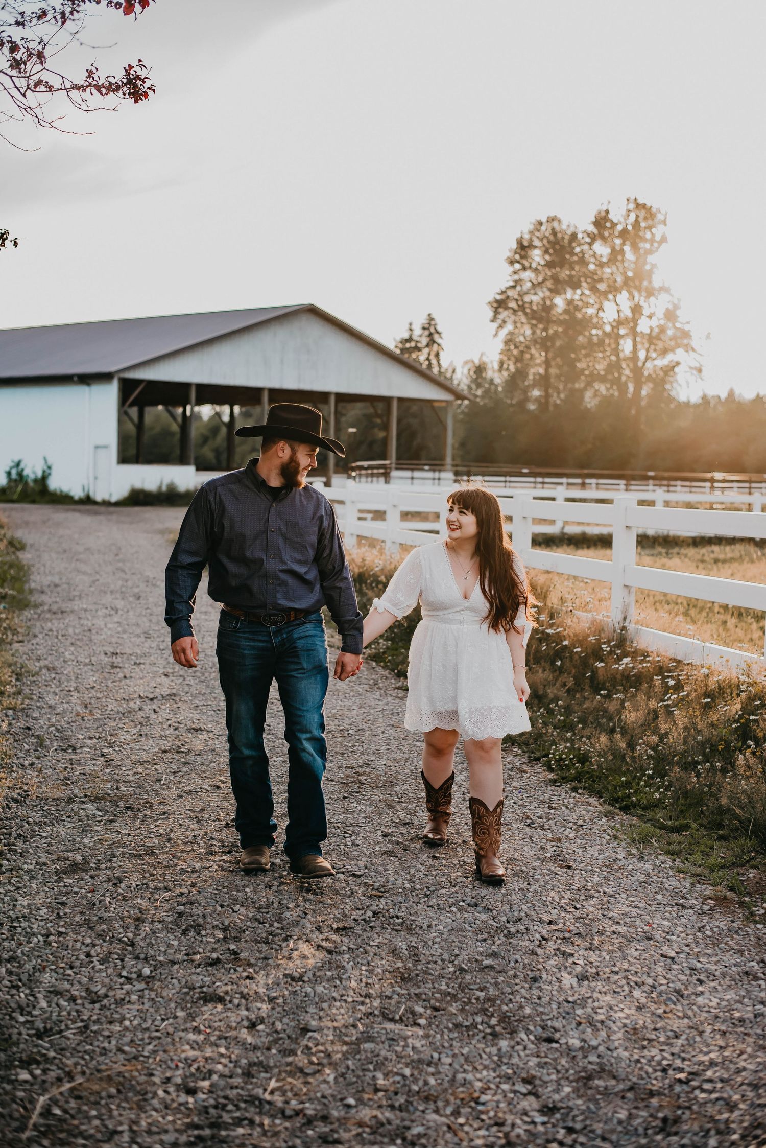 Couple walking along a path near a fence on a farm