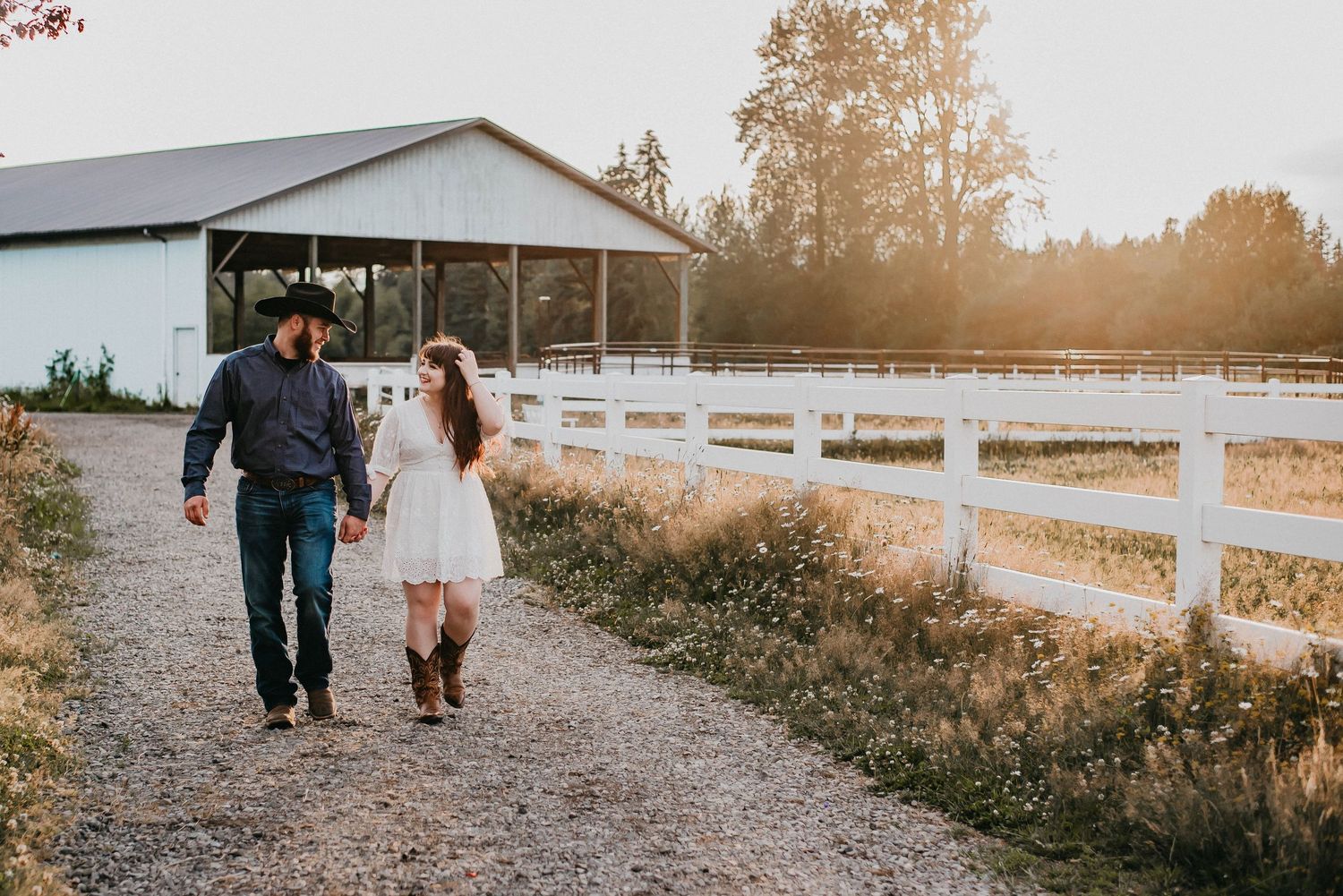 Couple walking along a path near a fence on a farm