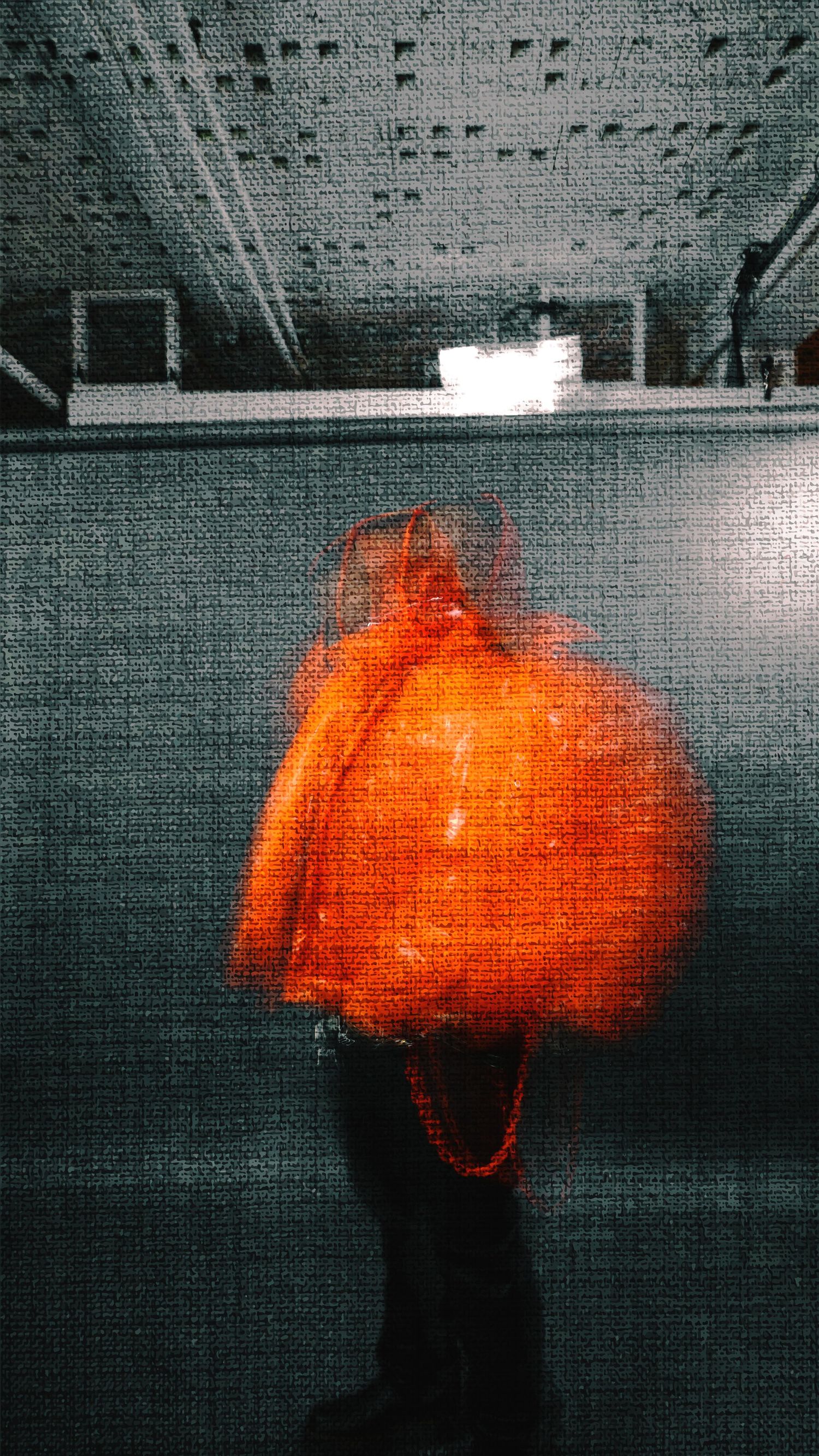 Motion blur sequence capturing bright orange movement against a gray industrial ceiling.