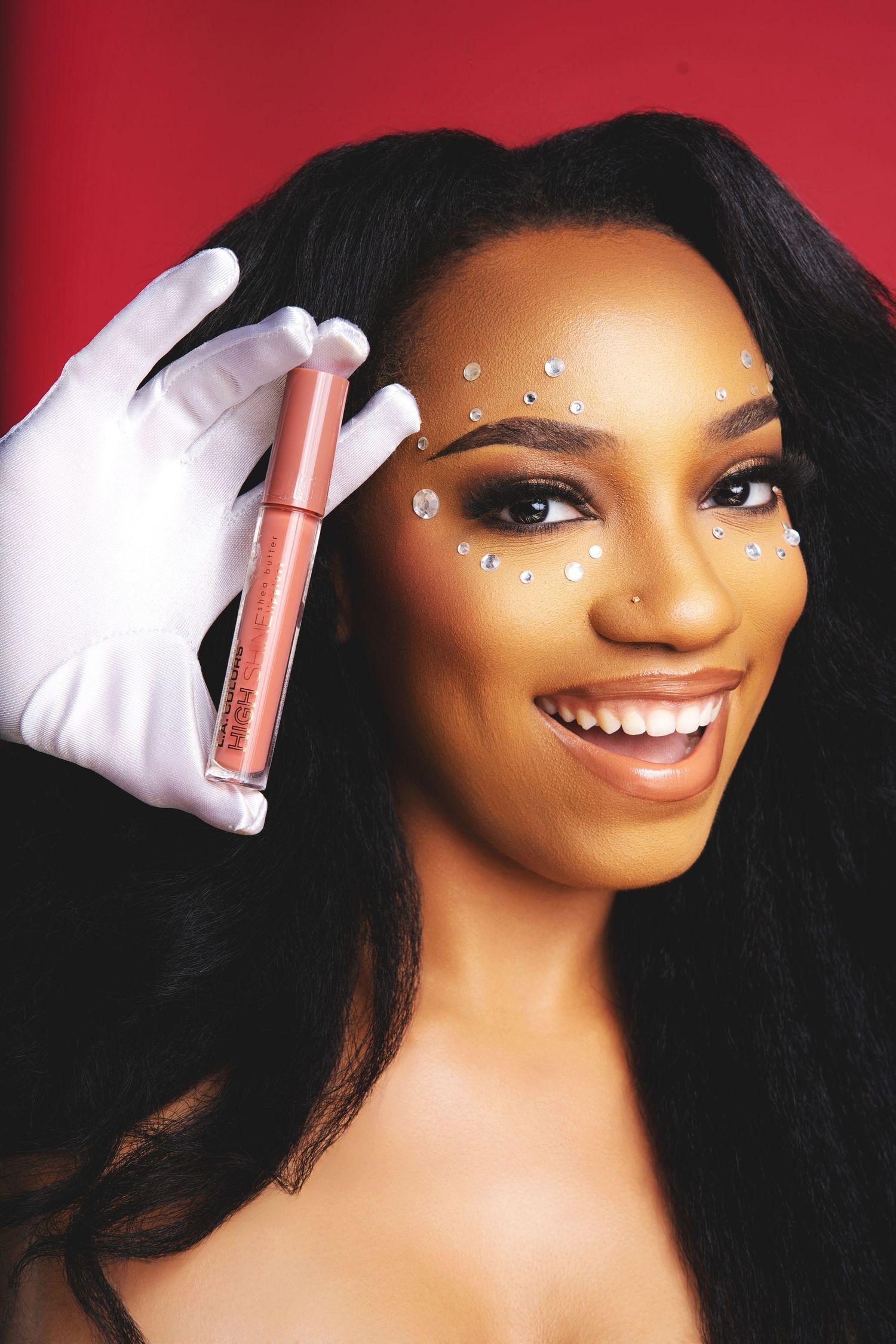 Cosmetic product photography session with white gloves holding pink beauty products.