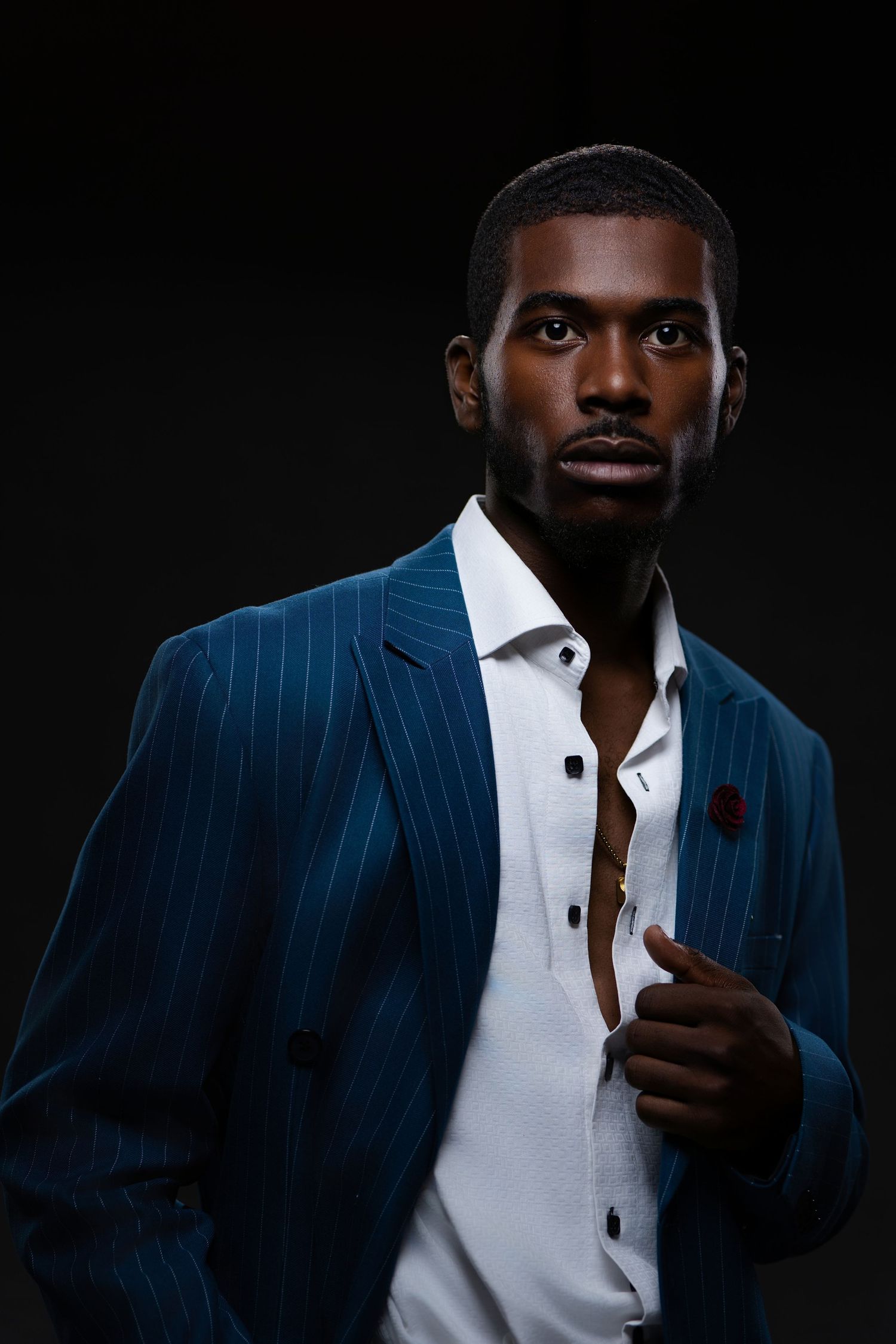 Professional portrait series showing a person in a navy pinstripe suit against dark background.
