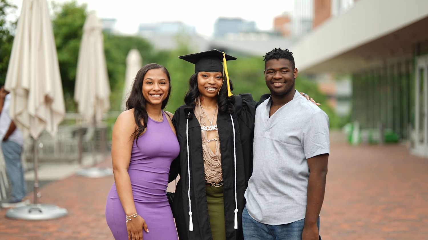 Graduates and family members gather outdoors for photos on graduation day.
