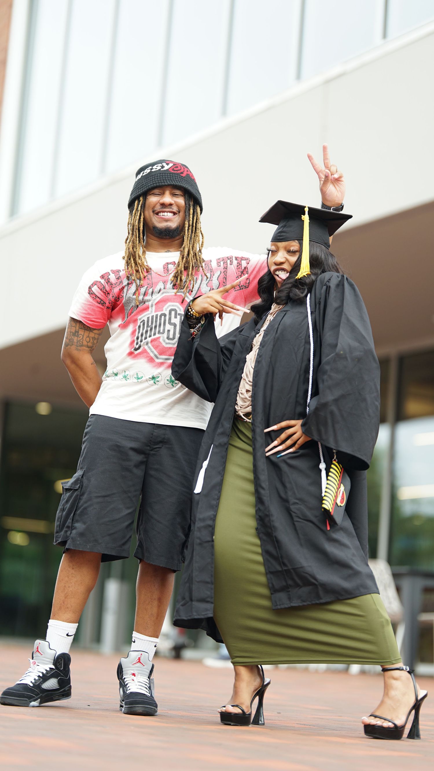 Graduates in academic regalia pose together during graduation celebration.