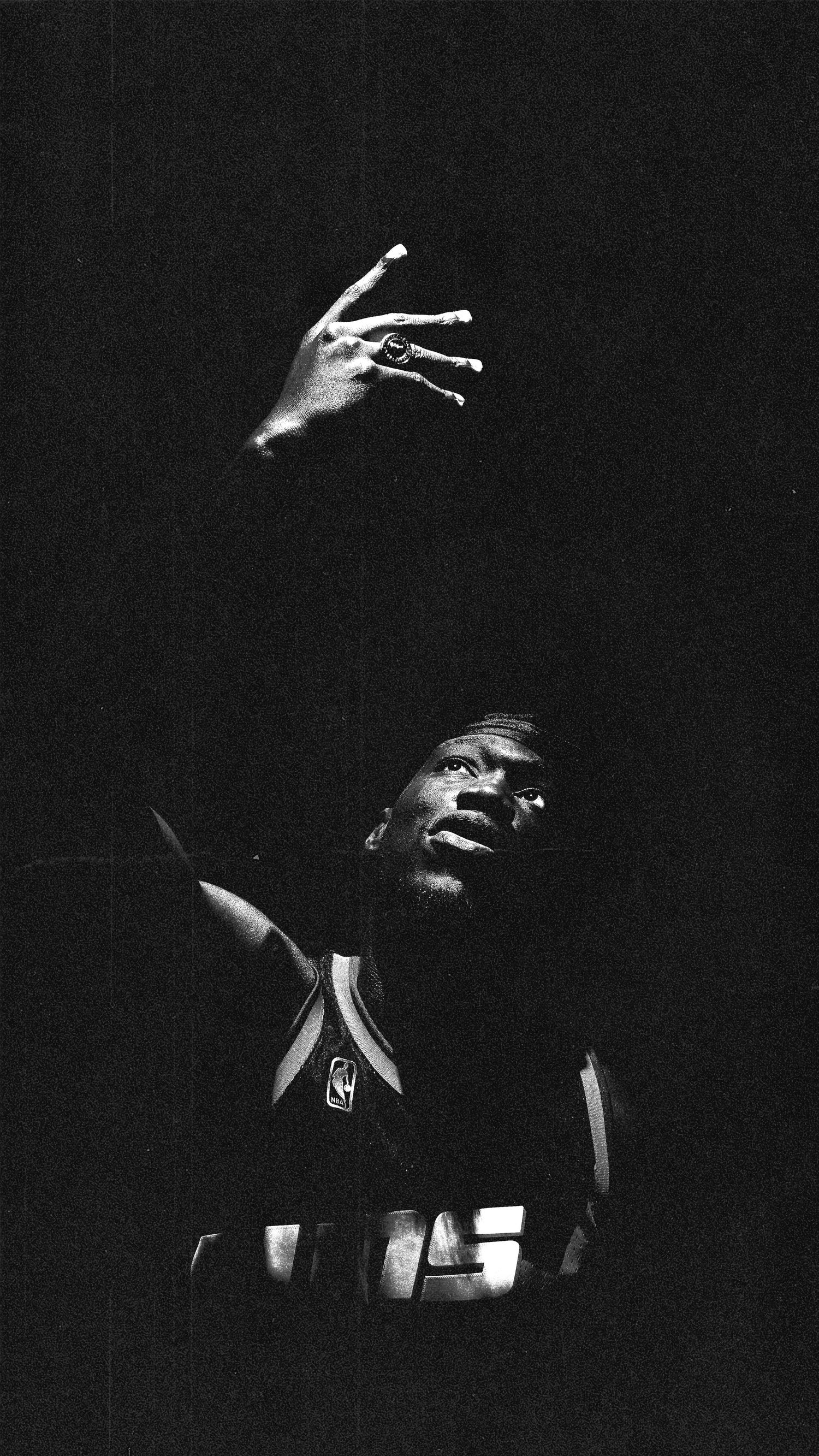 Basketball player's silhouette against dark background with dramatic lighting effects.