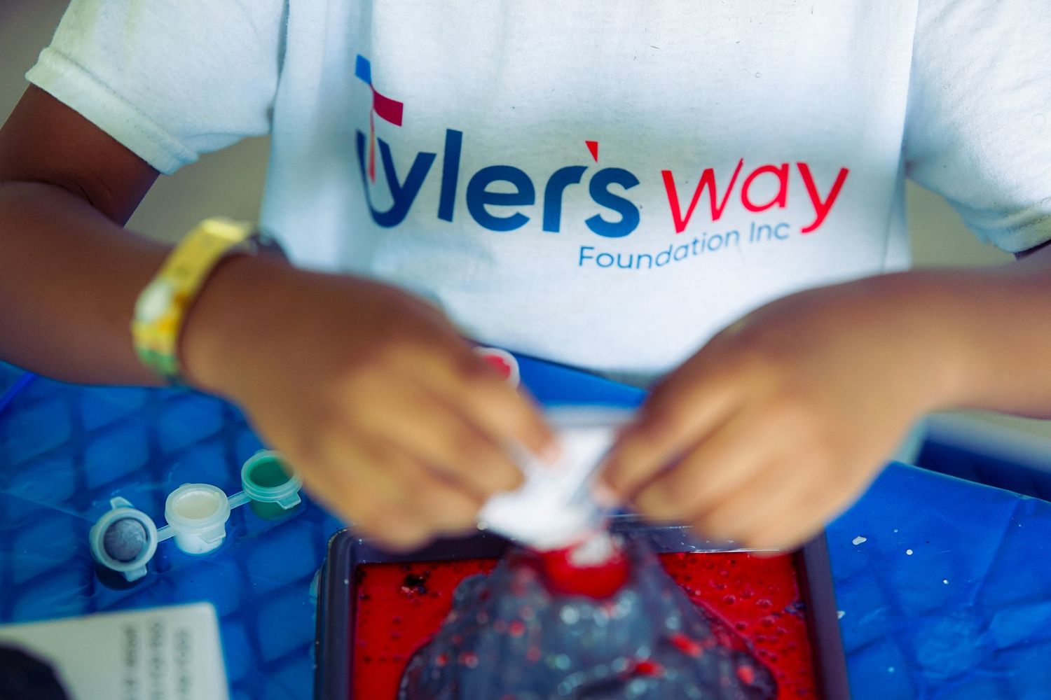 Tyler's Way Foundation volunteer assembles craft supplies at charity event for children.