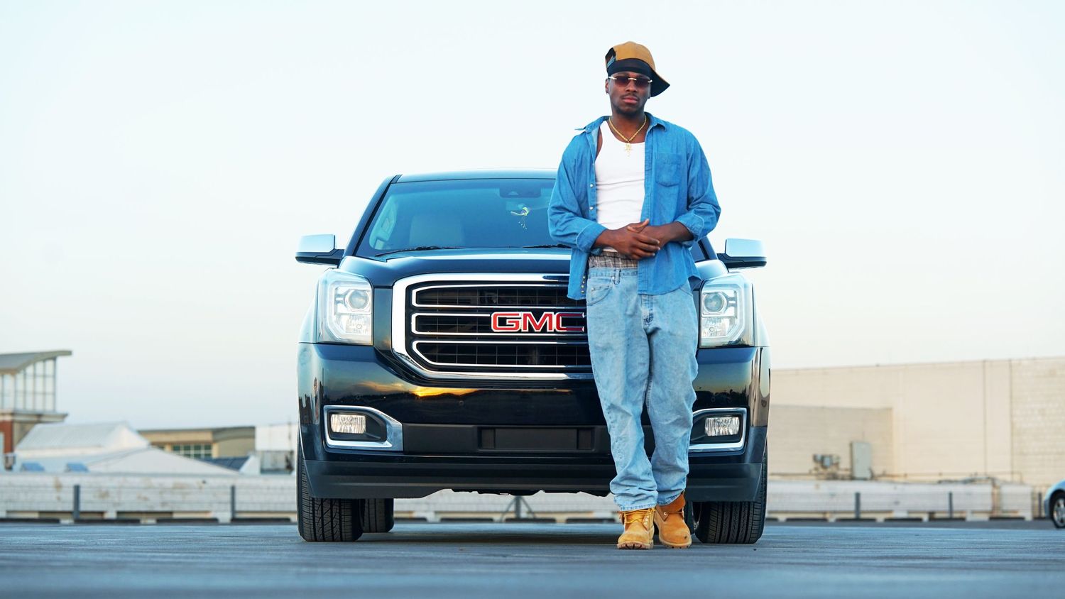 Casual denim outfit styled with luxury SUV in outdoor parking lot setting.