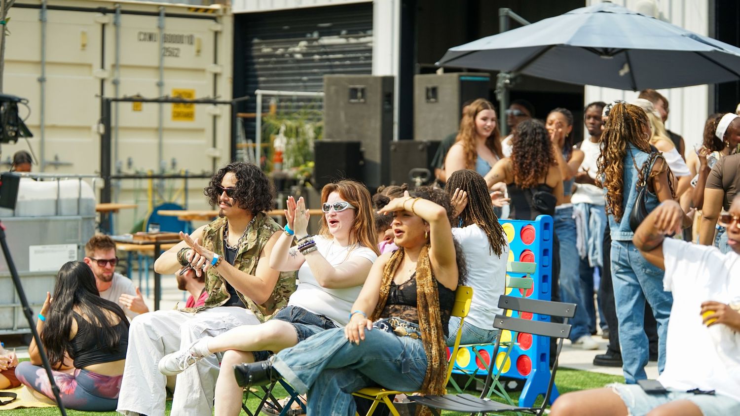 Crowd of spectators holding up phones to capture a moment at an outdoor event.