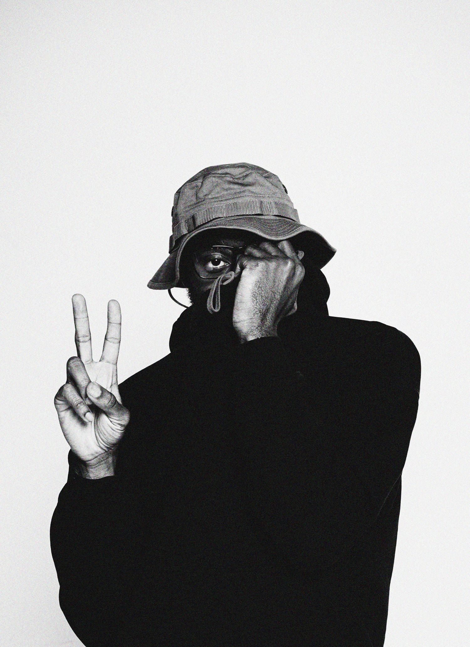 Black and white sequence showing a silhouetted figure making peace signs against a white background.