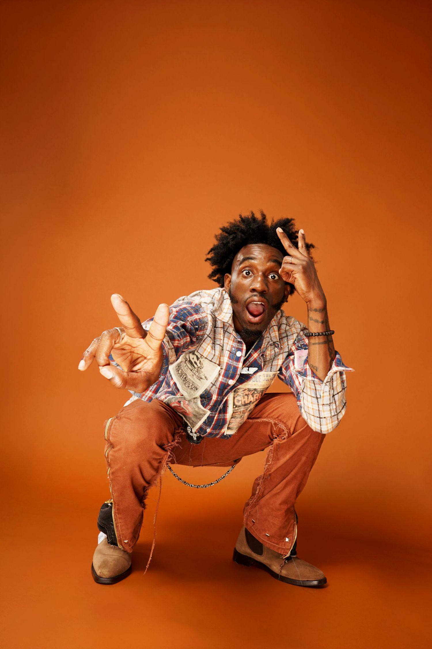 Energetic figure in plaid shirt performing dynamic poses against orange background.