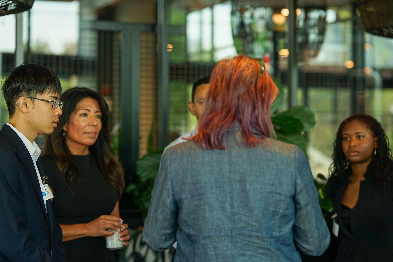 Small group of diverse professionals having a discussion at an indoor networking event.