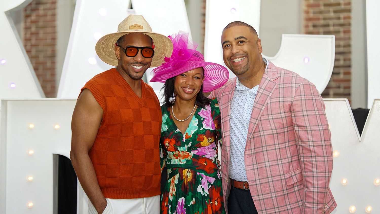 Festive group photo of people in colorful formal attire at a celebration.