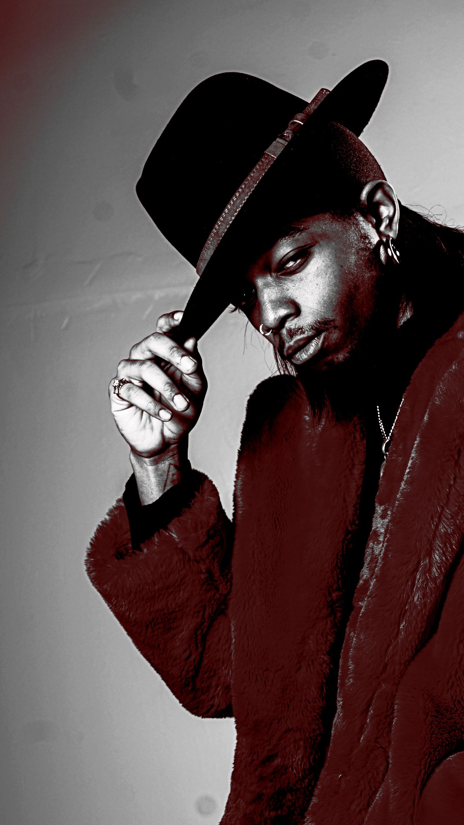 Artistic portrait series in red and black tones featuring someone in a dark hat and coat.