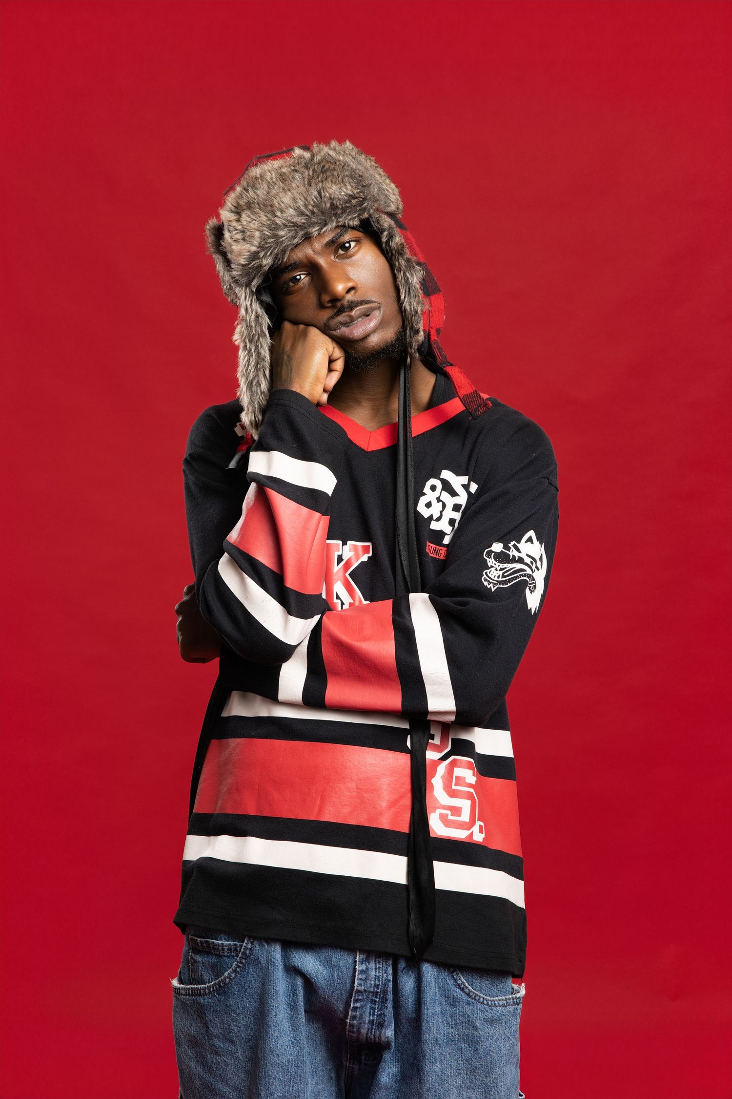 A fashion photo series showing winter outerwear with red, black and white colorblocking against a red studio backdrop.