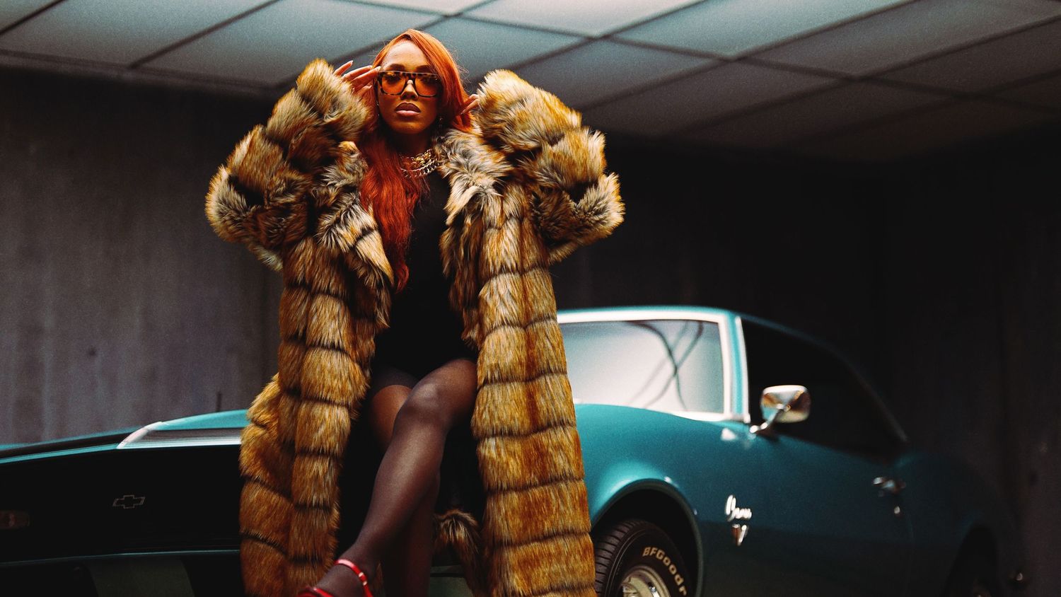 Luxury fashion shot with fur coat posed against vintage car.
