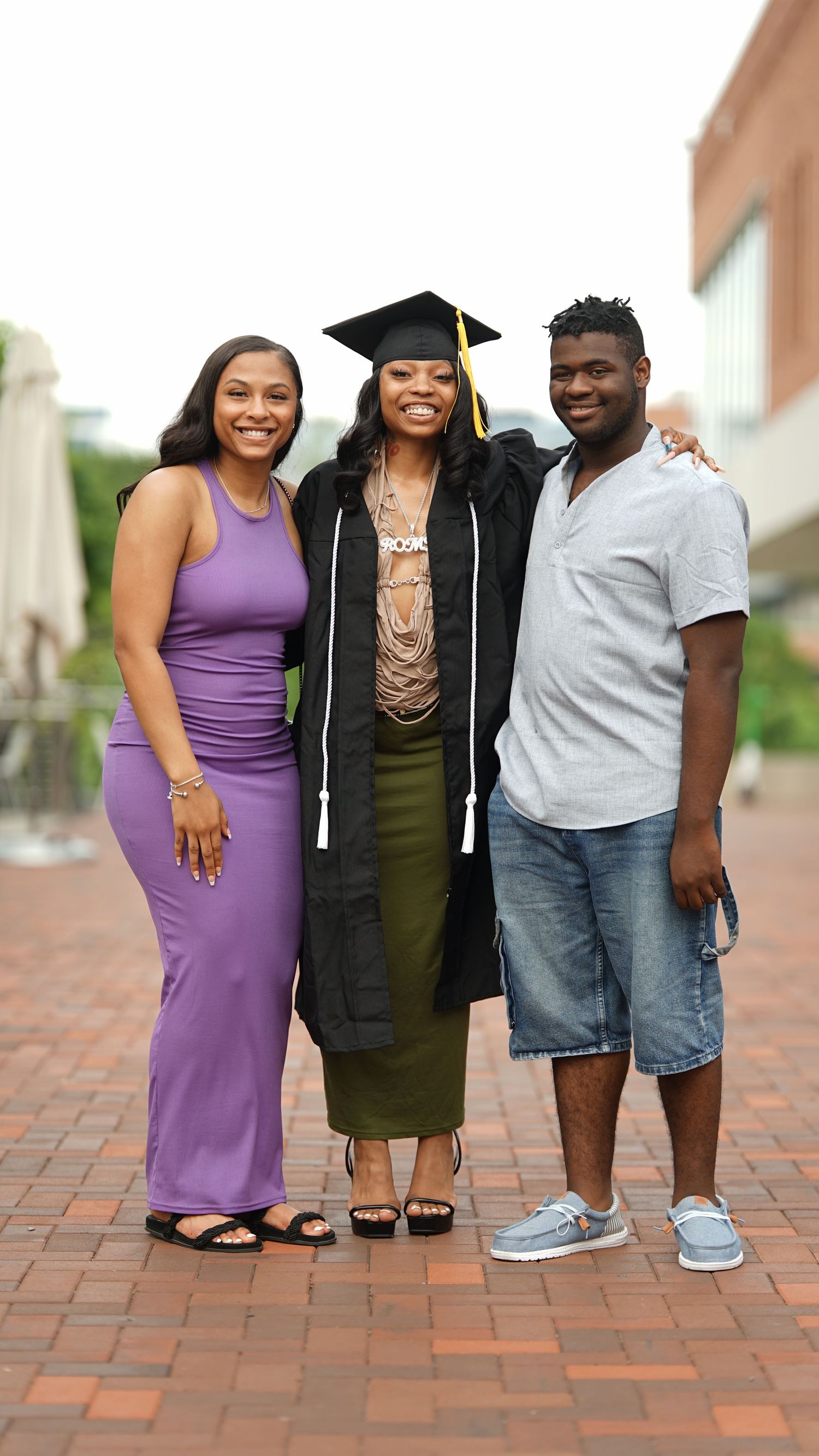 Family members pose together on brick patio during graduation celebration.