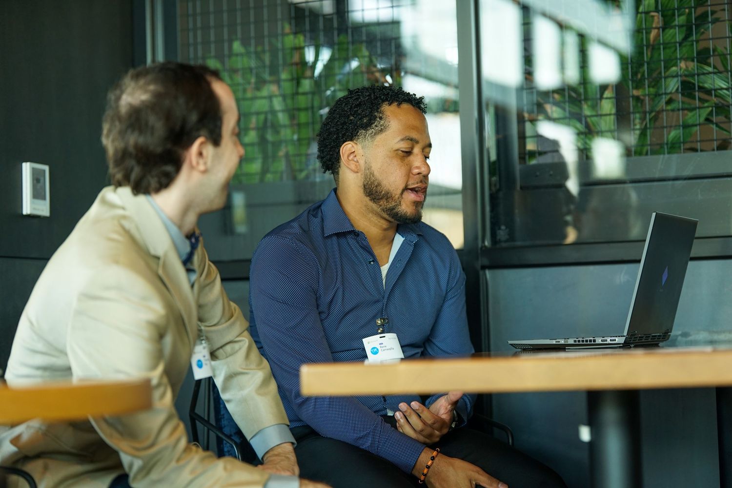 Two professional men collaborating over a laptop during a business networking meeting.