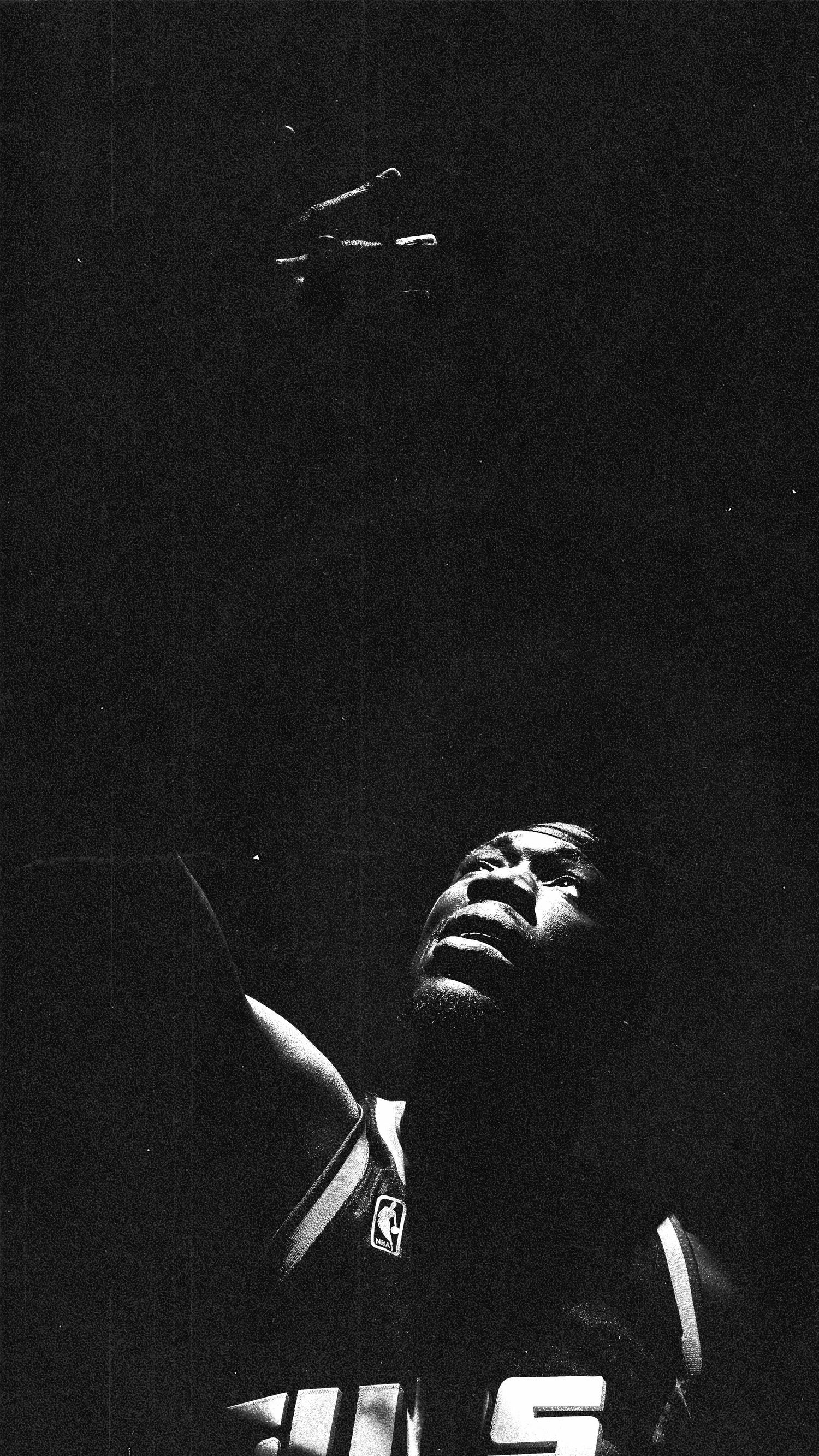 Basketball player in NBA jersey captured in dramatic shadows and lighting.